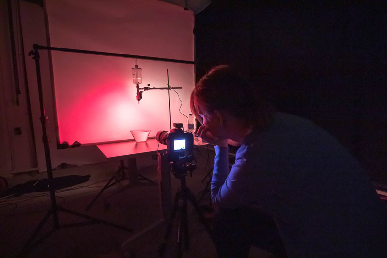 Dark photography studio setup with red lighting effects.