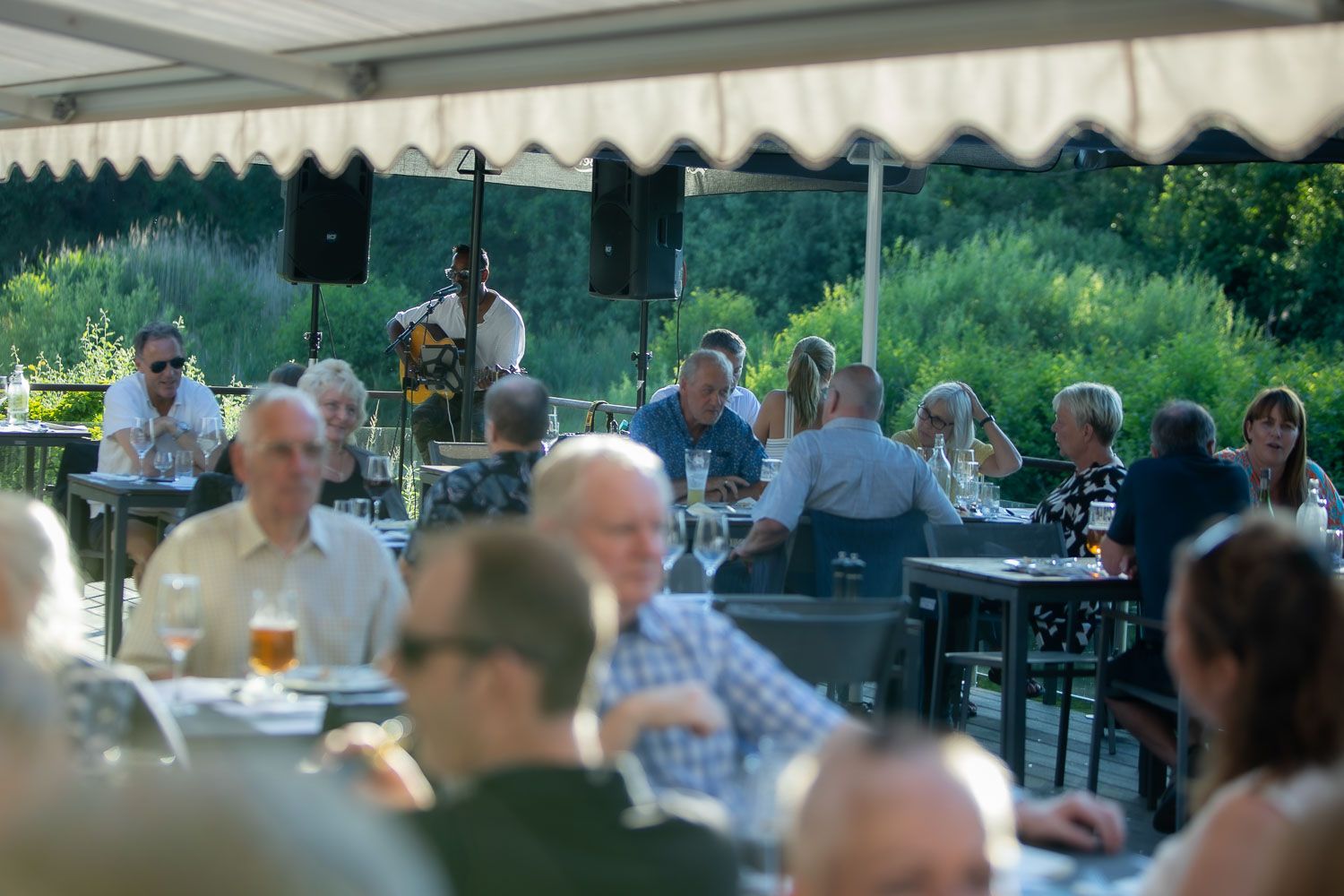 Covered outdoor dining area with guests enjoying summer meals.
