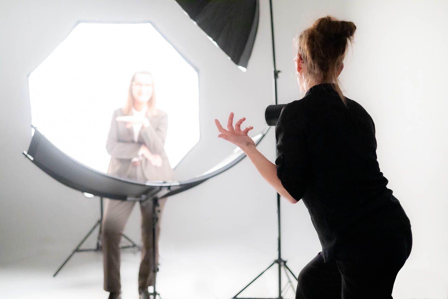 Studio photography session with lighting equipment and white backdrop setup.