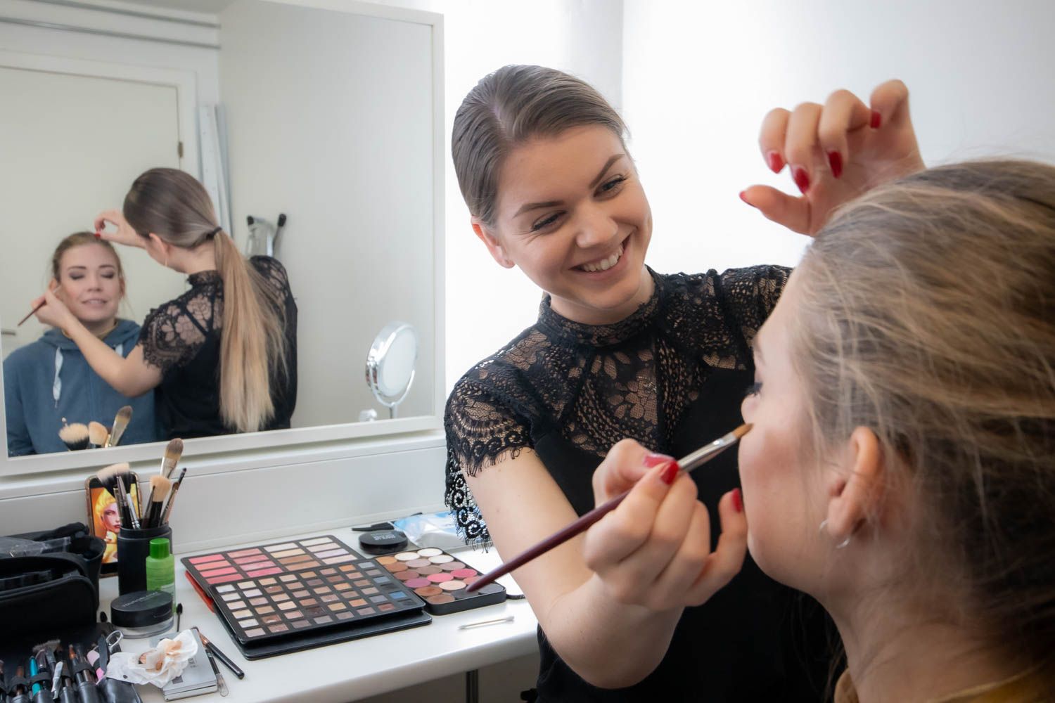 Makeup artist applying cosmetics during a professional photoshoot session.