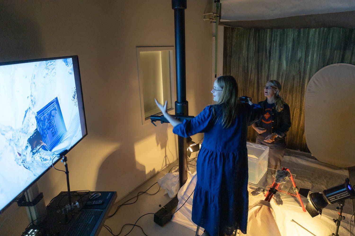 Photography studio space with blue lighting and professional equipment arranged for shooting.