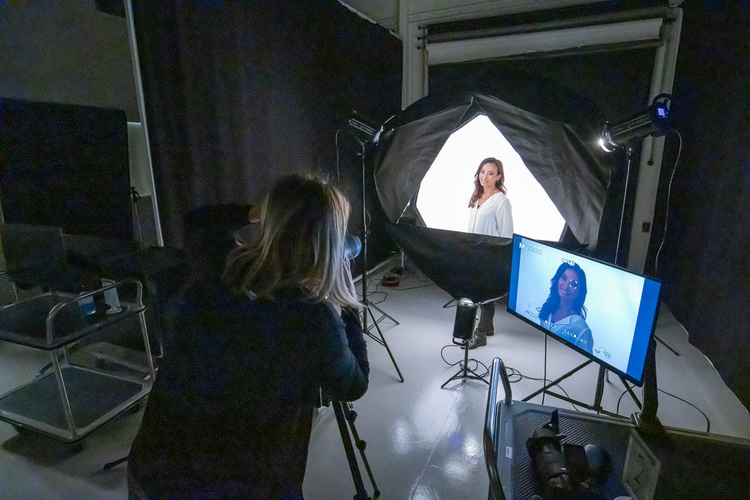 Professional photo shoot setup with softbox lighting and monitor display.