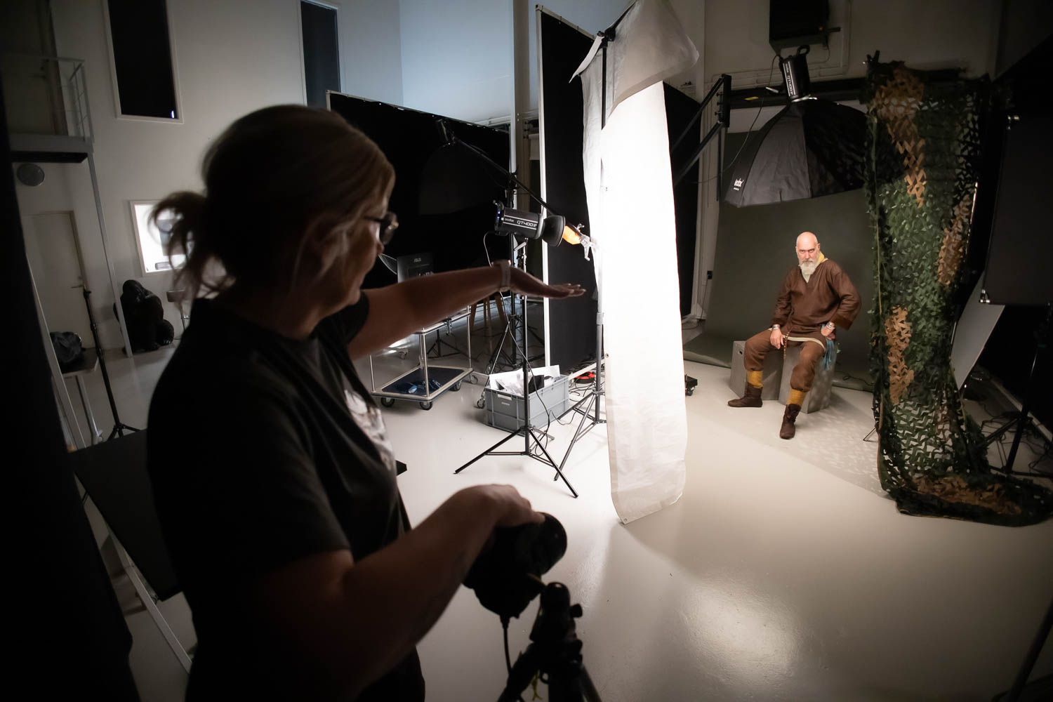 Behind the scenes photo shoot in studio with lighting equipment and backdrop setup.