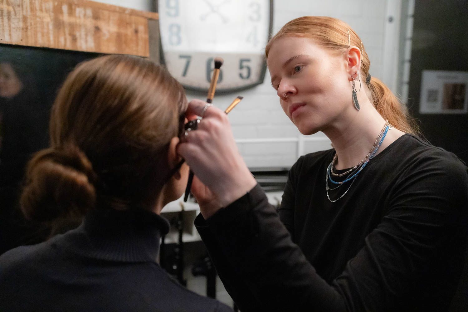 Makeup artist working on set during a professional photo shoot.