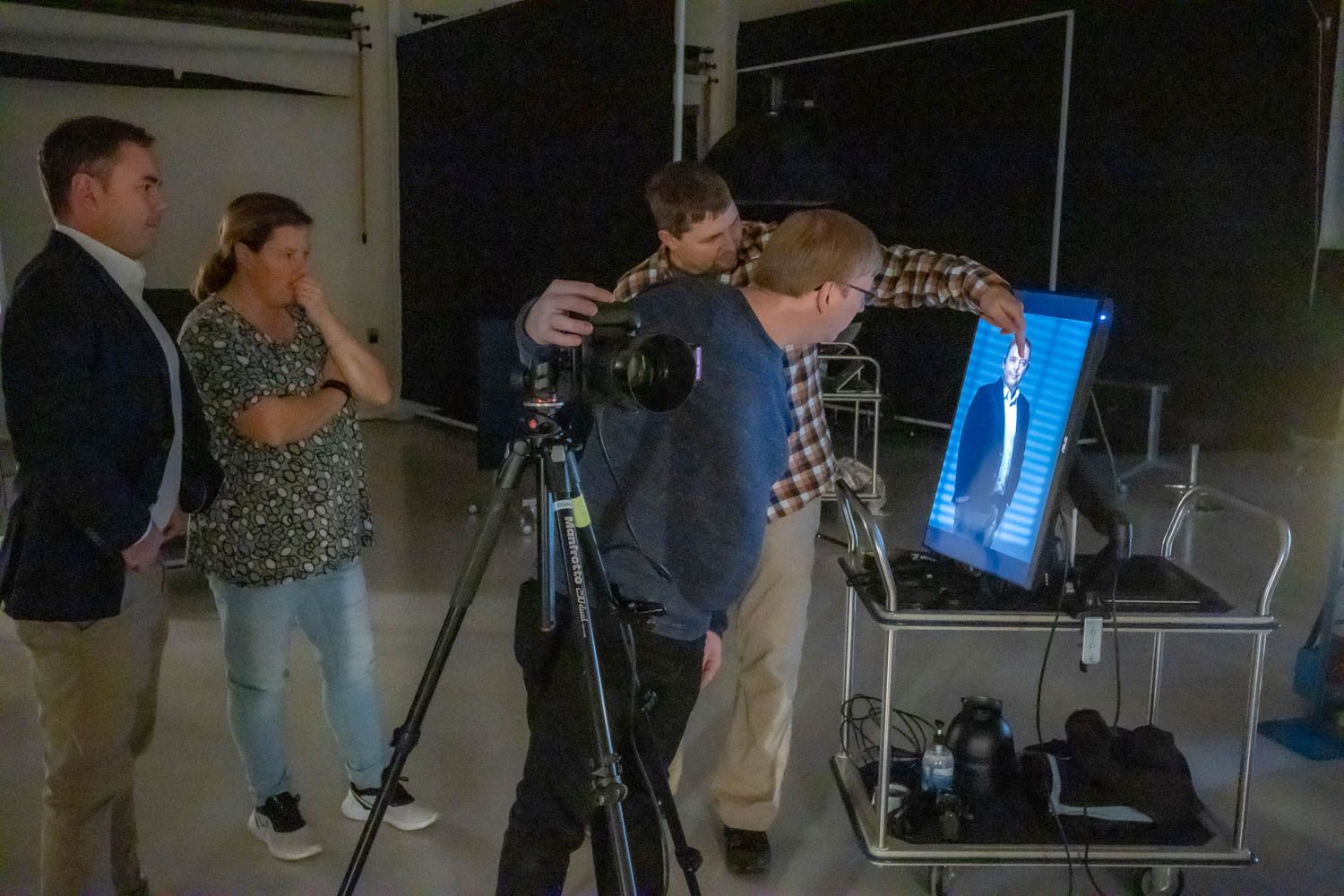 Photography crew setting up camera equipment in a studio space.
