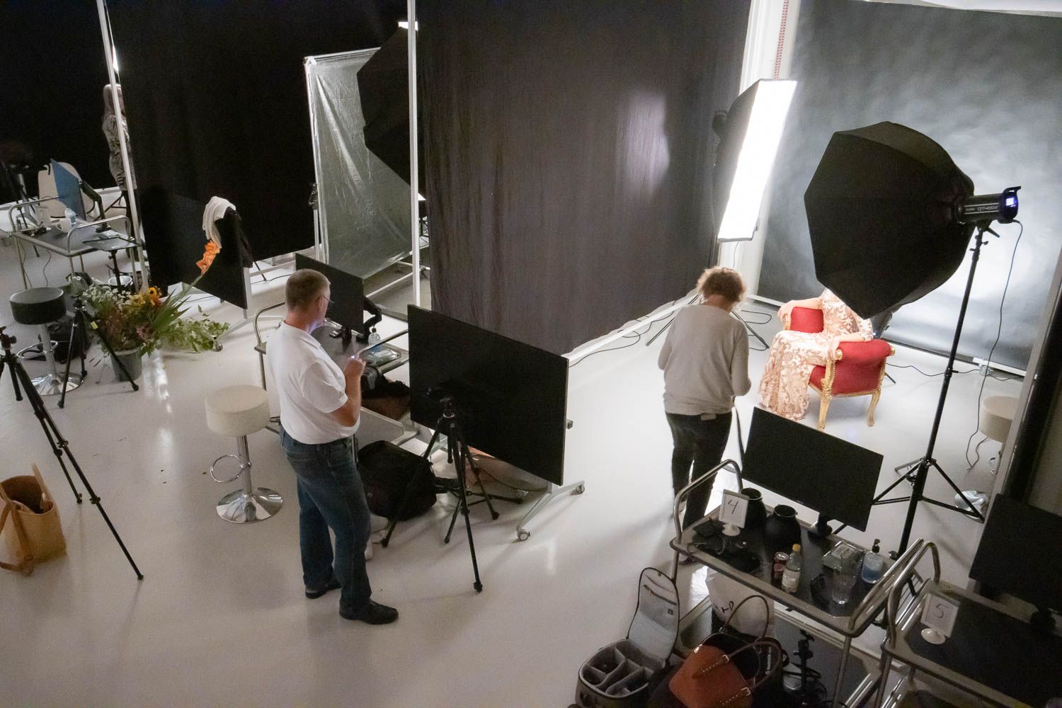Wide angle view of photography studio showing multiple lighting setups and equipment placement.