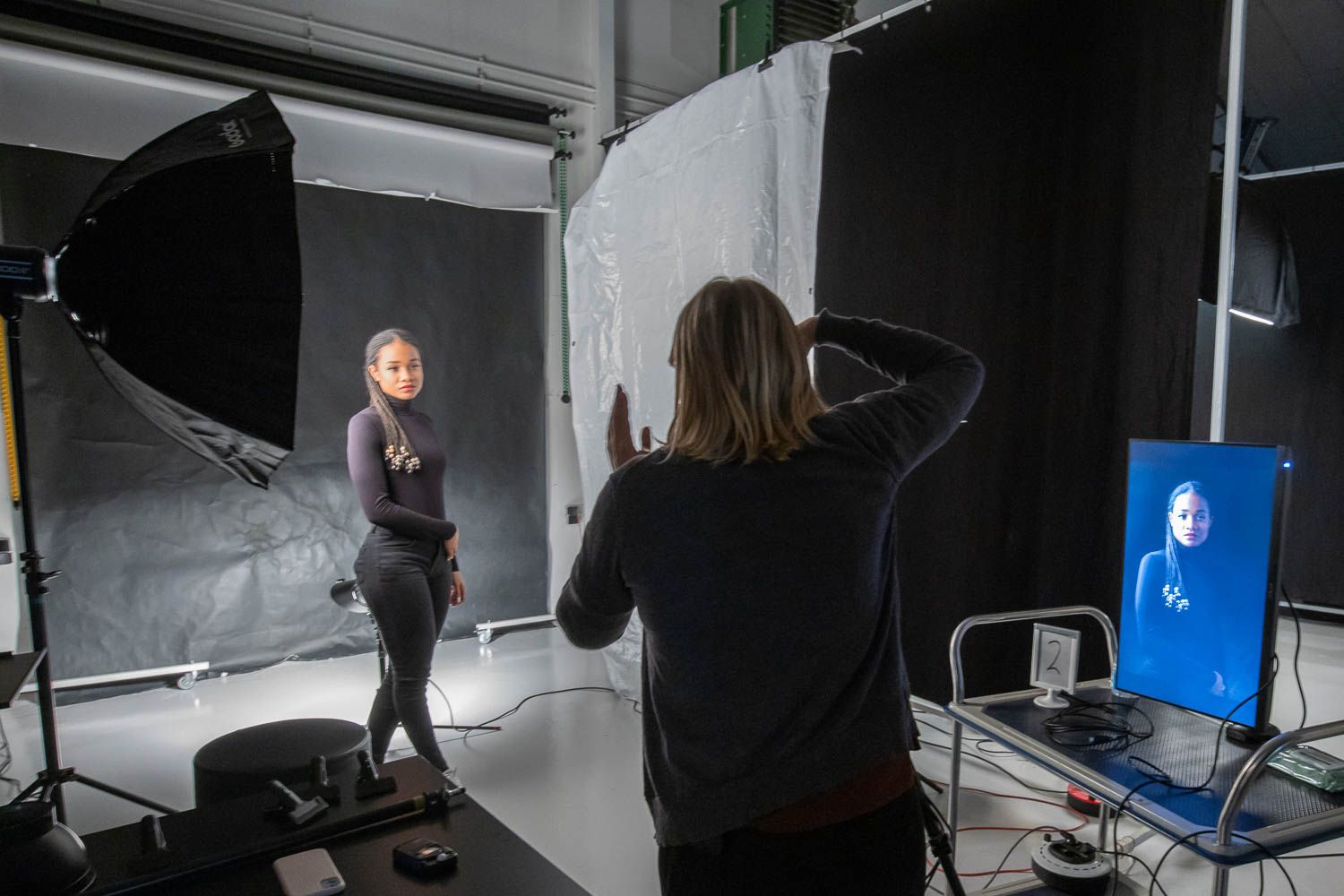 Studio photography setup with lighting equipment and backdrop screens.