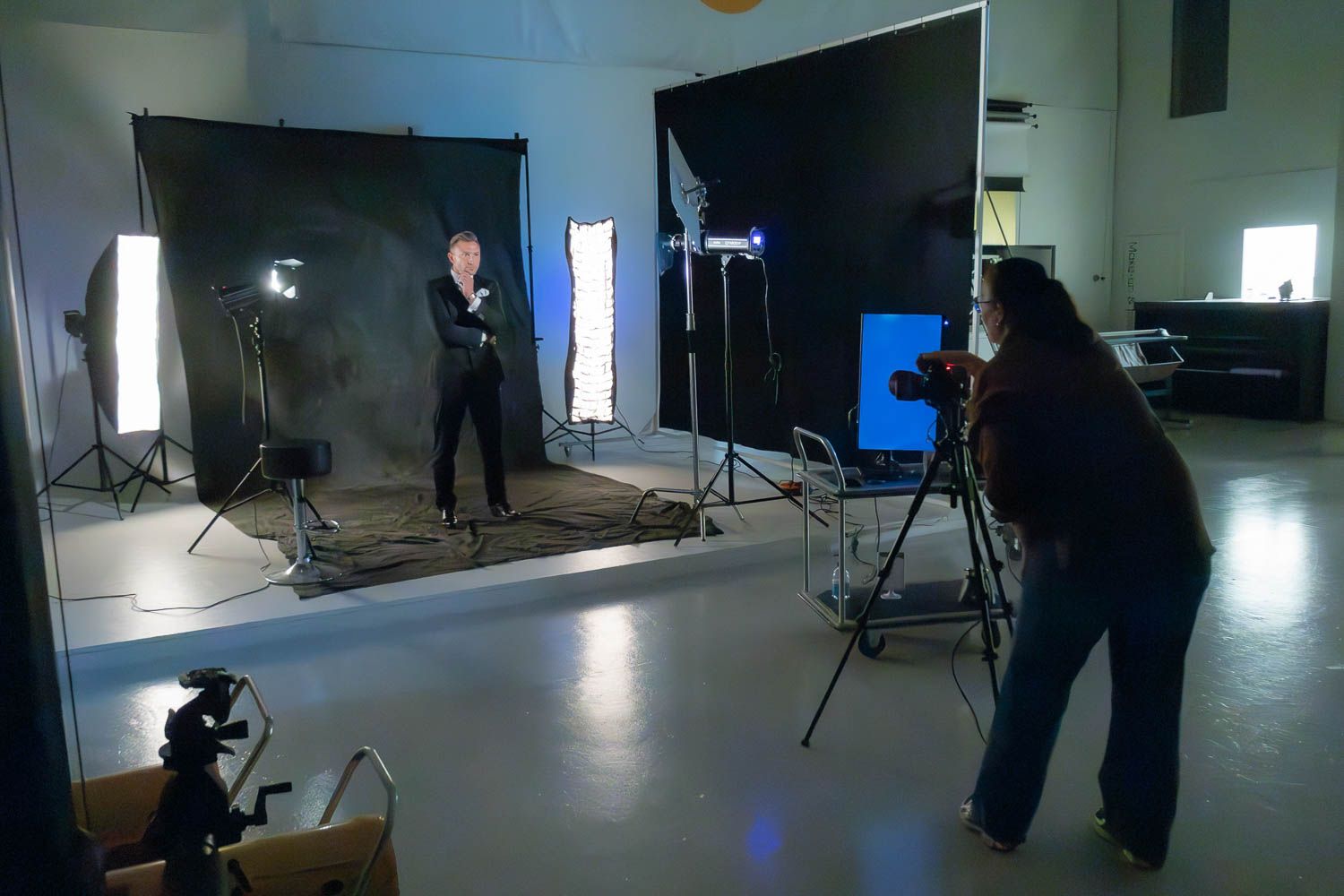 Wide angle view of an empty photography studio with professional lighting equipment setup.