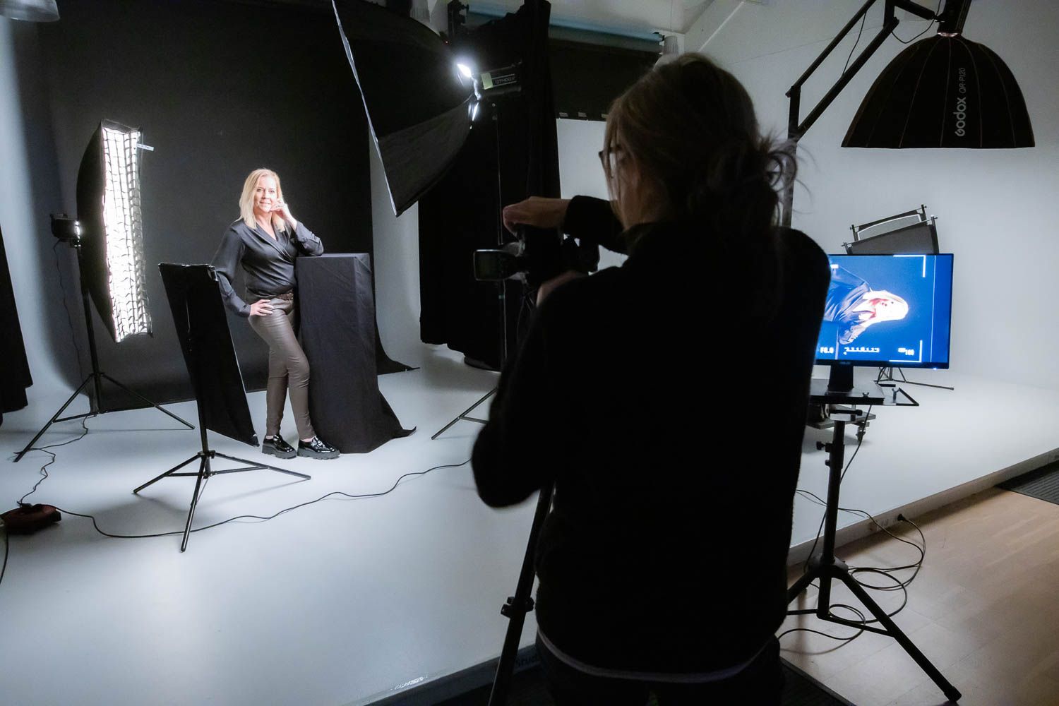 Behind the scenes of photo shoot showing lighting and camera equipment.