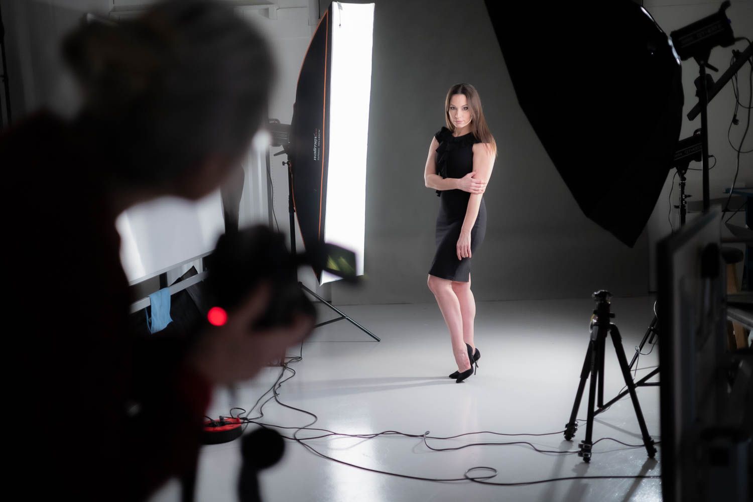 Photography studio with white backdrop and professional lighting setup.
