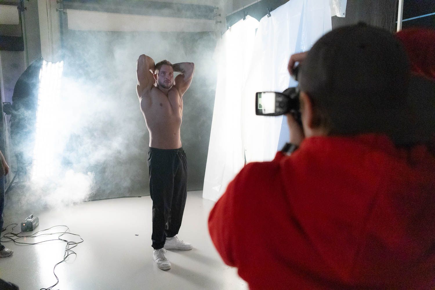 Smoke effects being used during a professional photo shoot in white studio space.