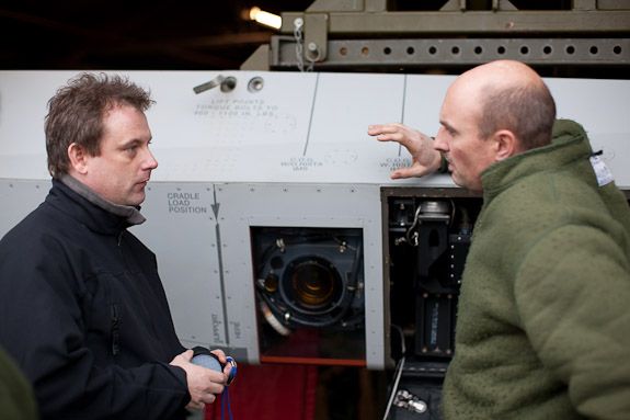 People inspecting technical equipment in an industrial facility.