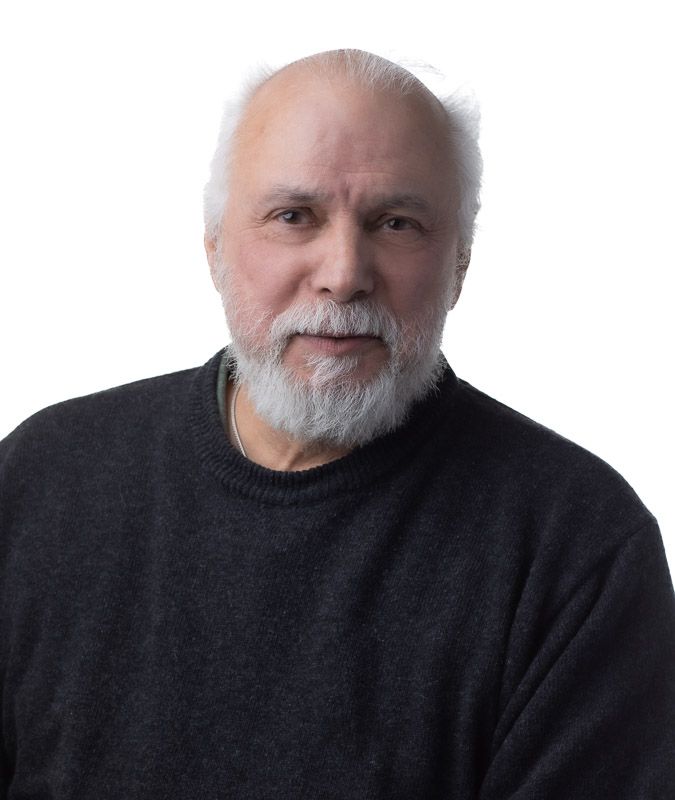 A portrait series showing different angles of someone wearing a black sweater with white hair and beard against a dark background.