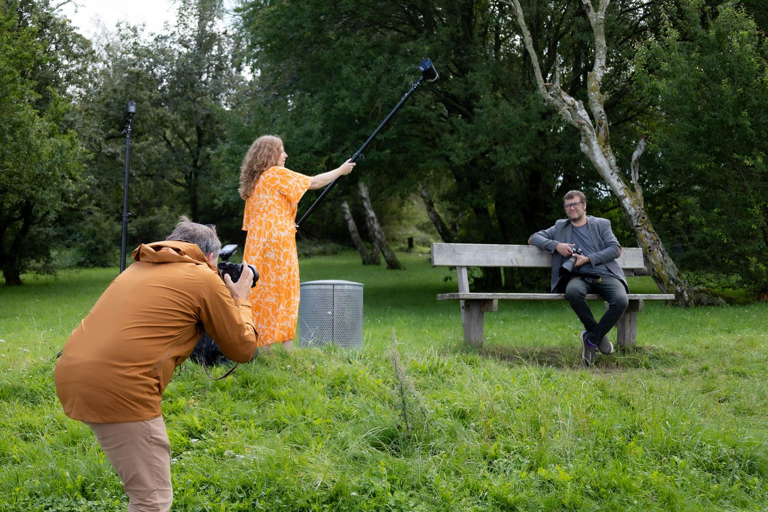 Outdoor photo shoot setup in a lush green park with camera equipment.