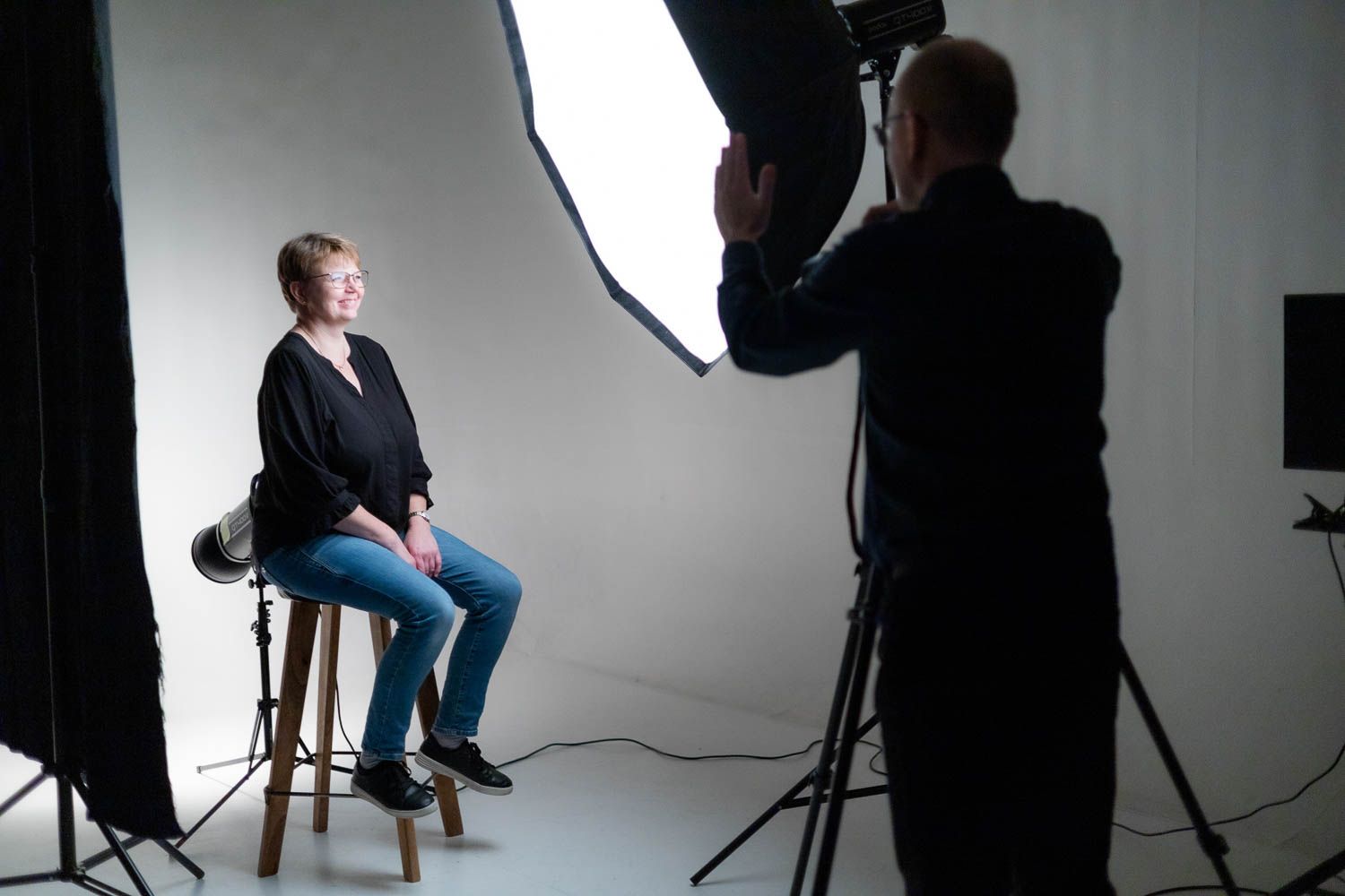 Studio photography session in progress with lighting equipment and white backdrop setup.