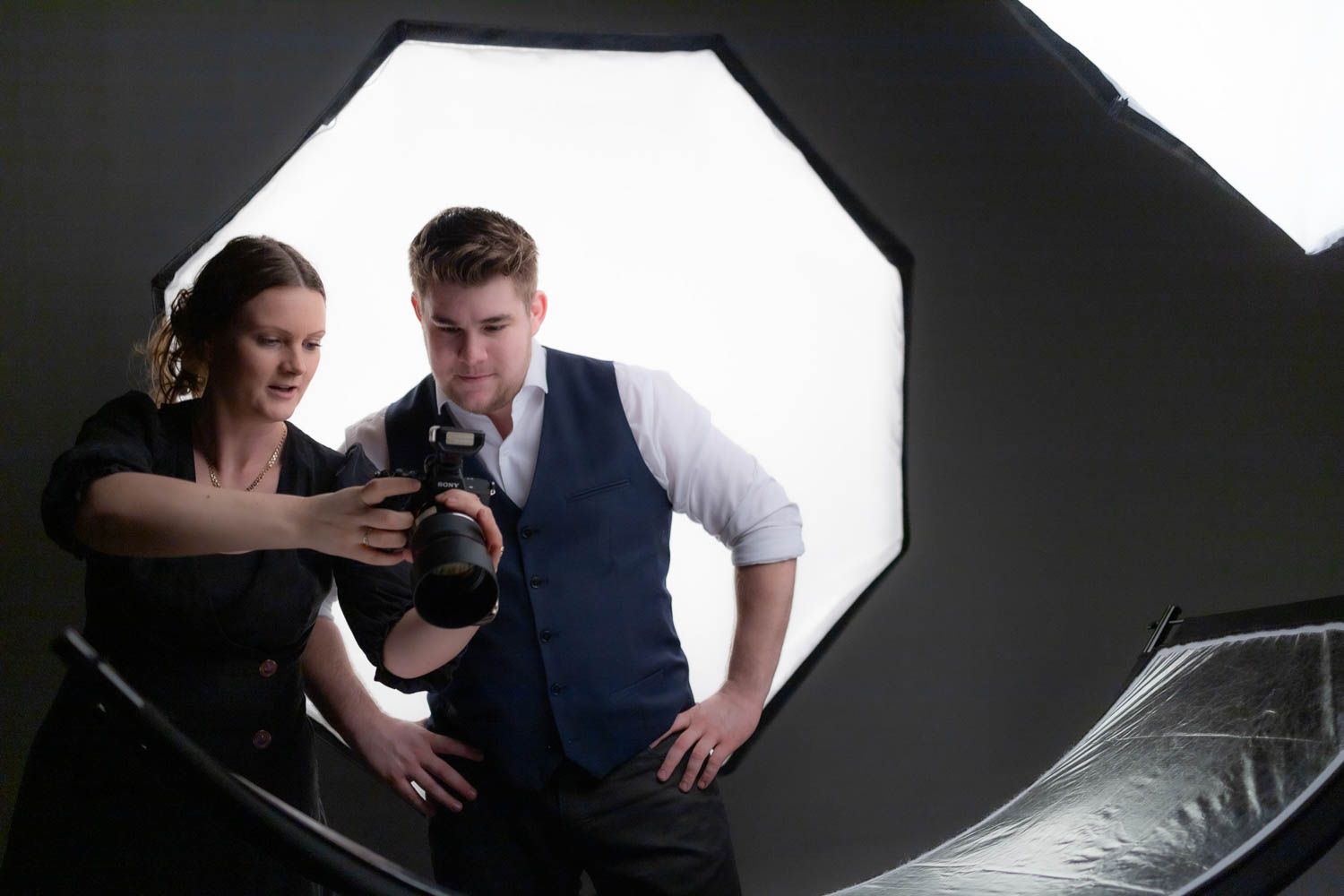 Professional photography session in progress with dark background and studio lighting.