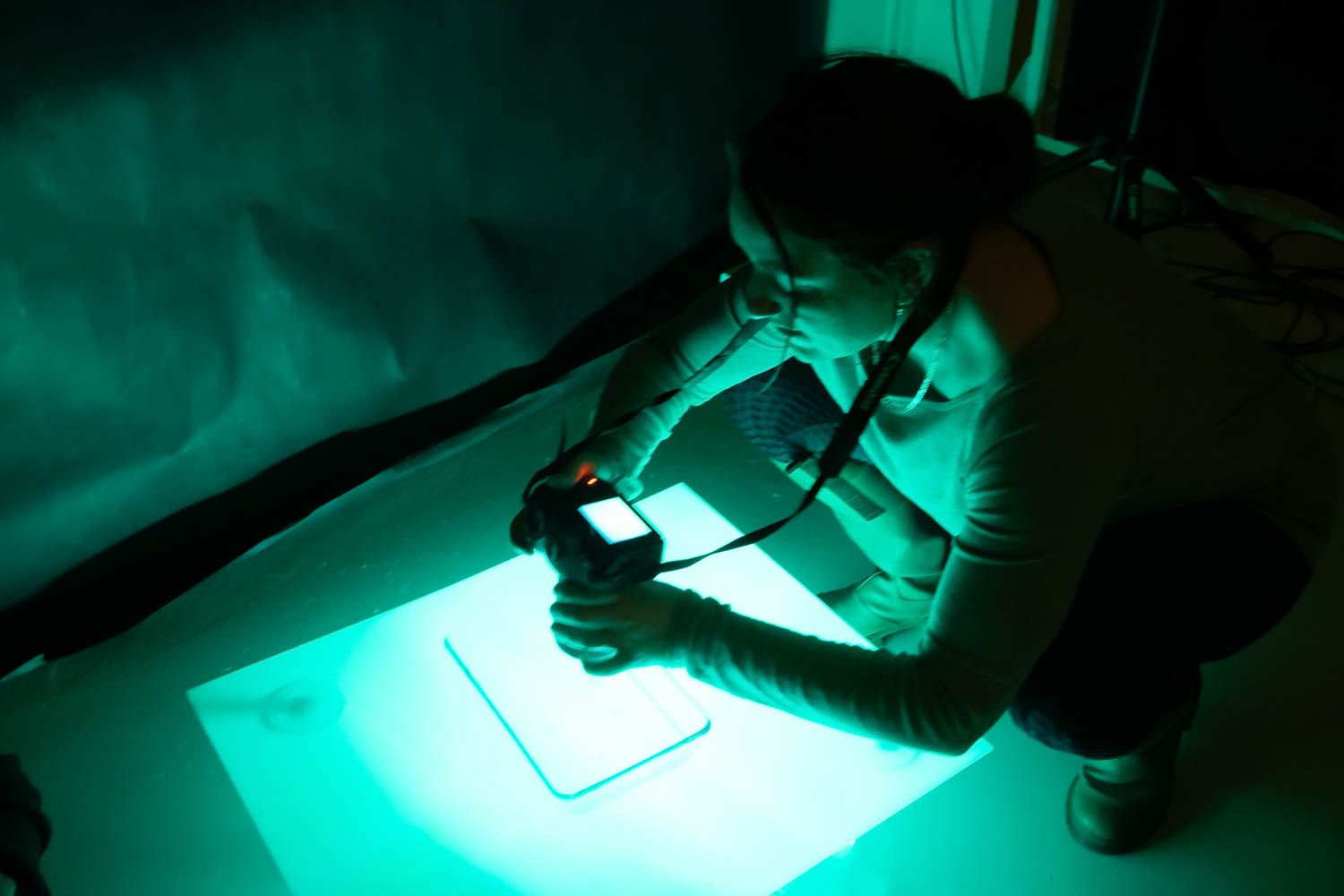 Photography equipment casting green lighting effects in a dark studio setting.
