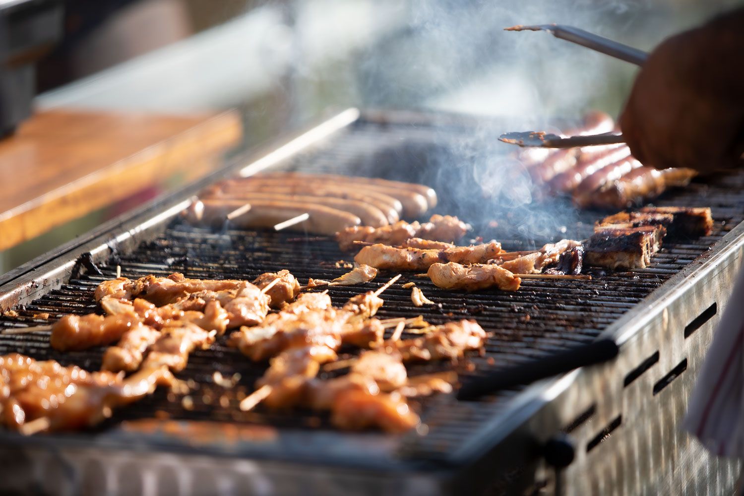 Close-up of meat sizzling on a professional barbecue grill grates.
