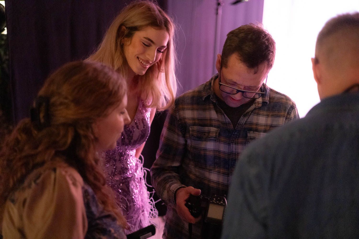 Studio photography session with dramatic purple lighting and professional equipment.