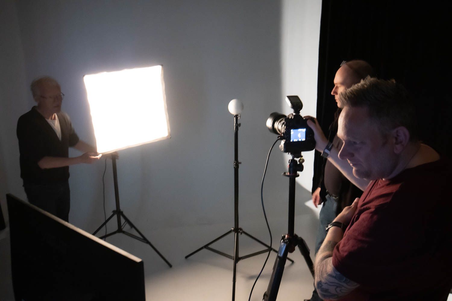 Studio lighting setup with dramatic shadows and professional photography equipment.