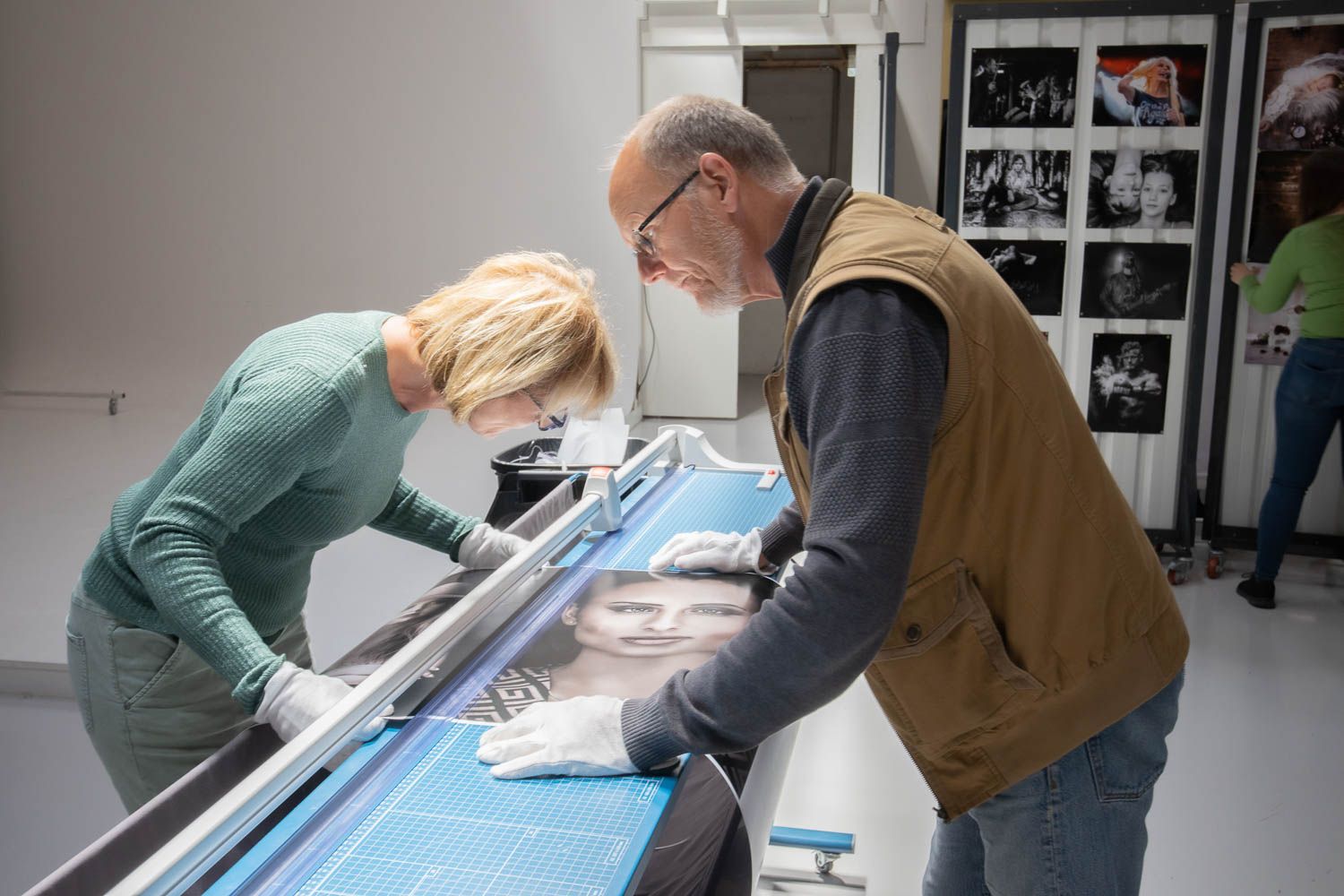 People examining large format prints laid out on a light table.