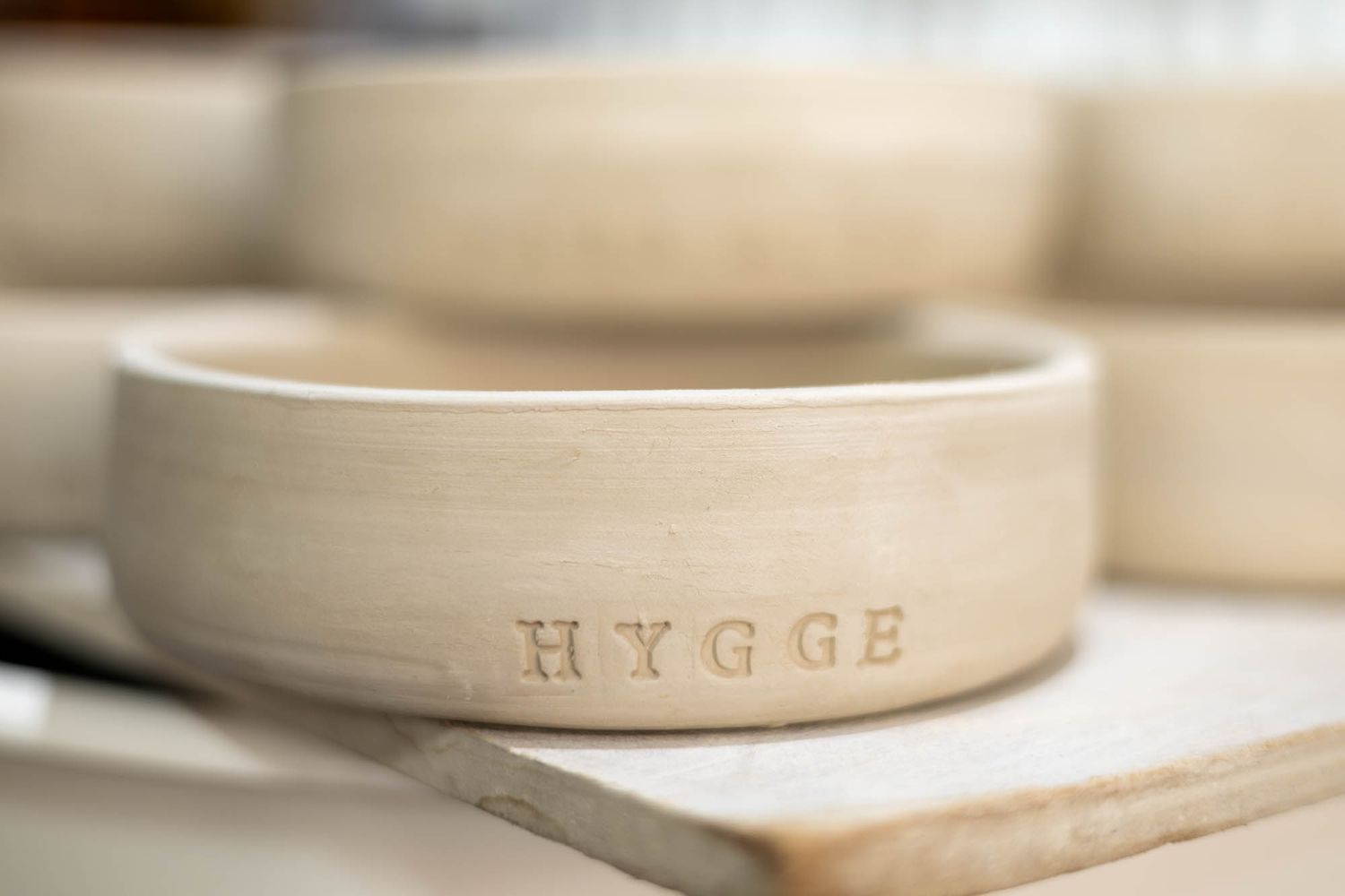 Close-up view of handcrafted ceramic pottery pieces in soft neutral tones.