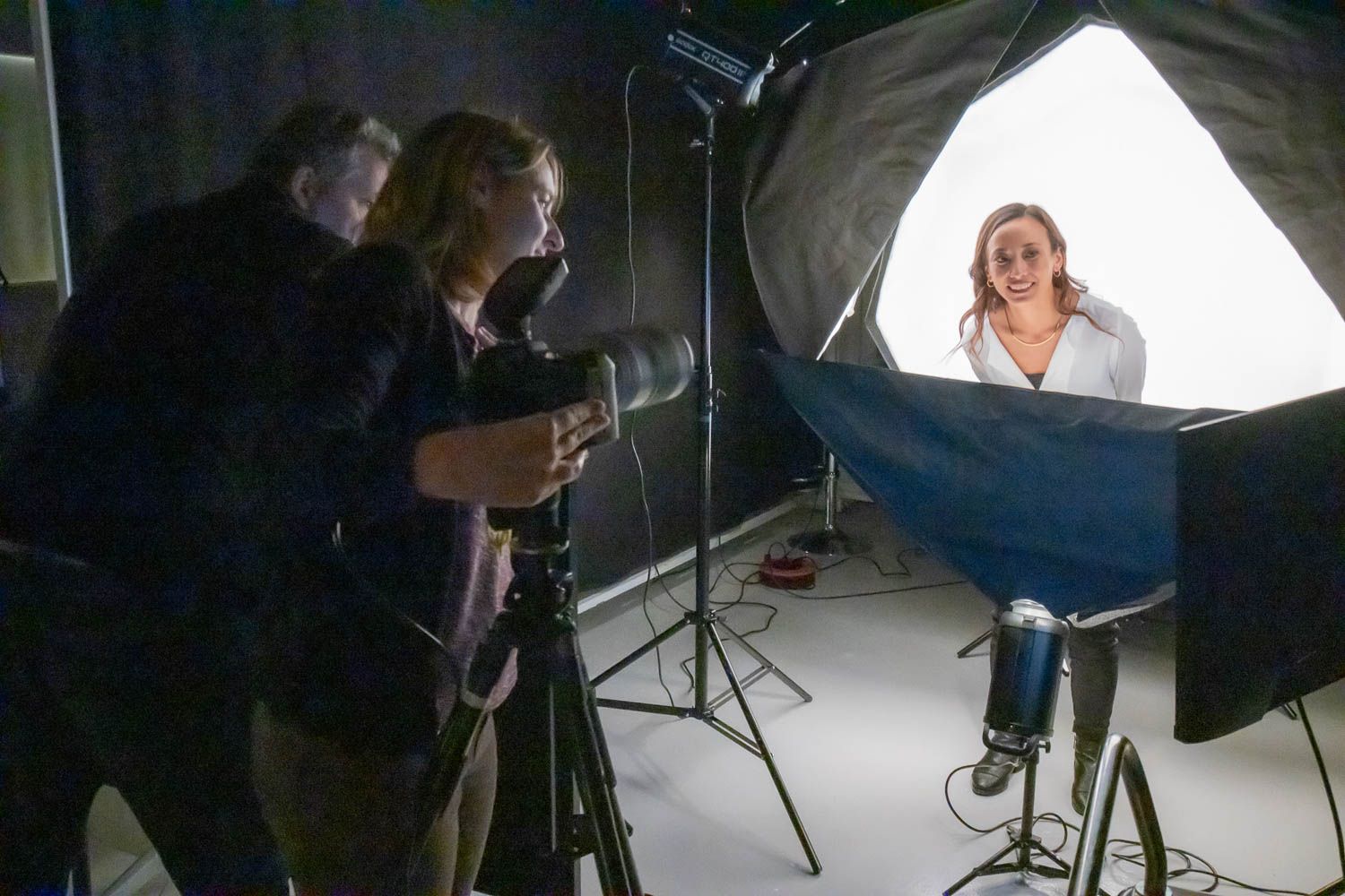 Behind-the-scenes view of photographers working with studio lighting equipment.