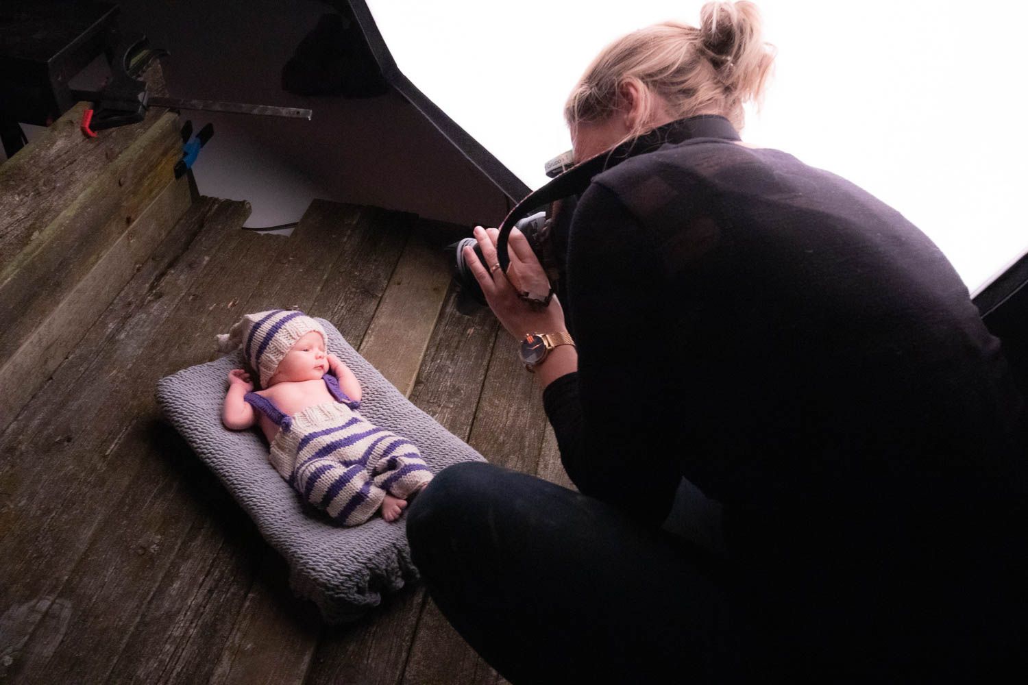 Behind the scenes photo shoot setup with lighting equipment and camera gear in a studio.