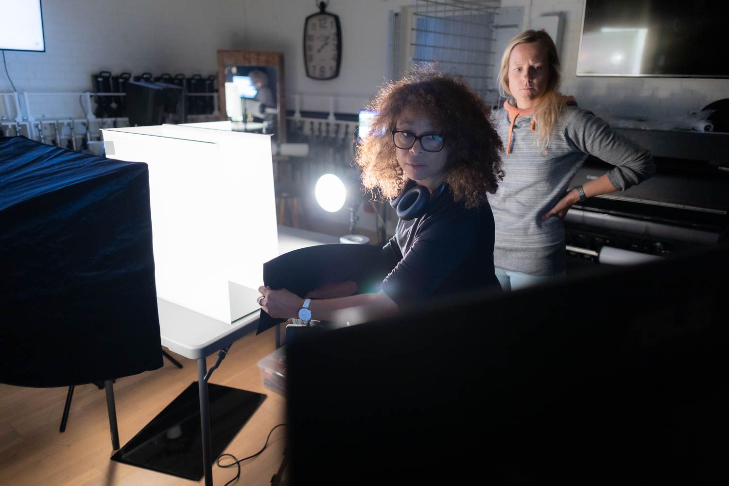 Dark studio space with scattered lighting equipment and production gear.
