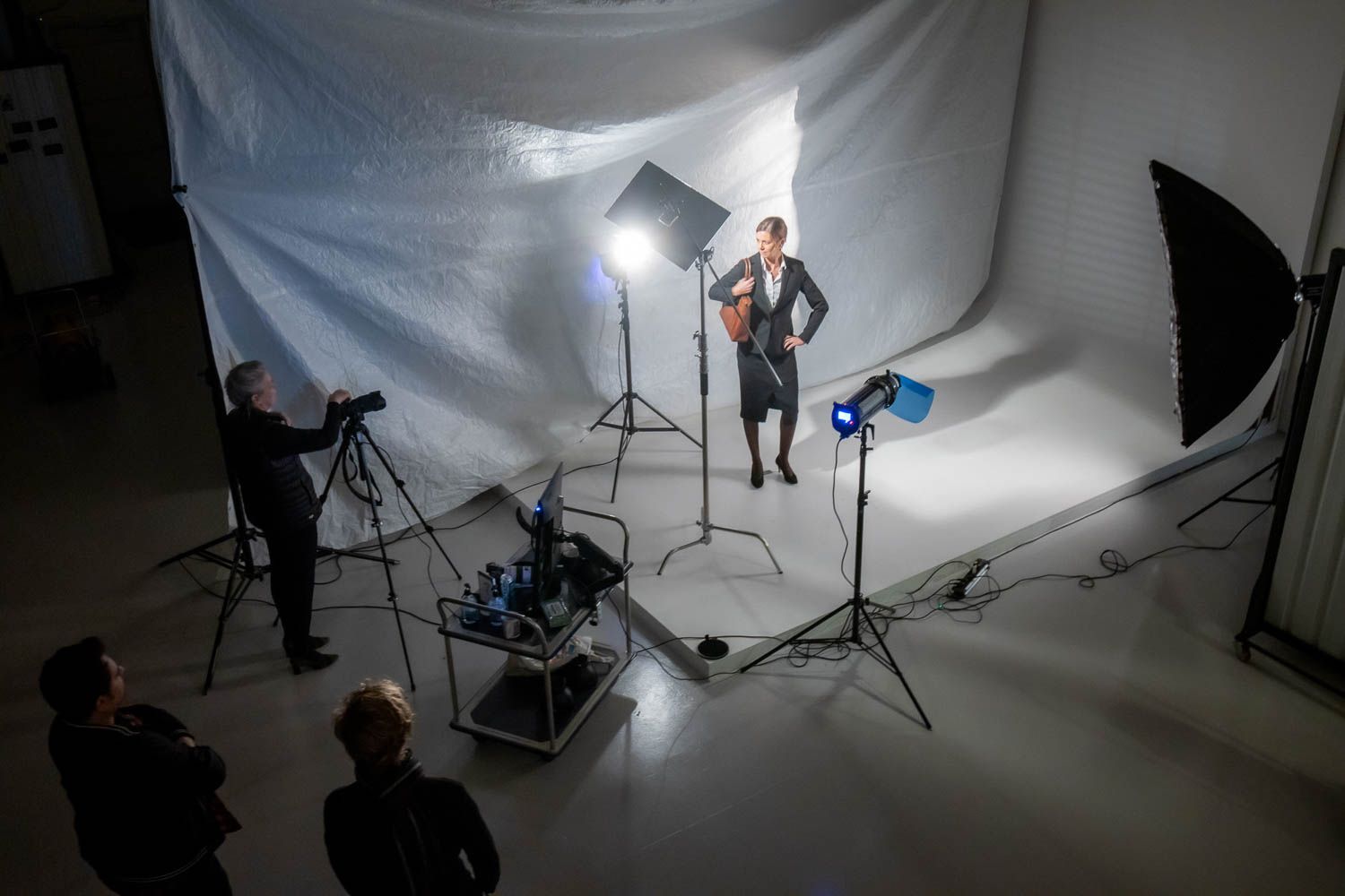 Studio photography setup with white seamless backdrop and lighting equipment arranged for professional shoot.