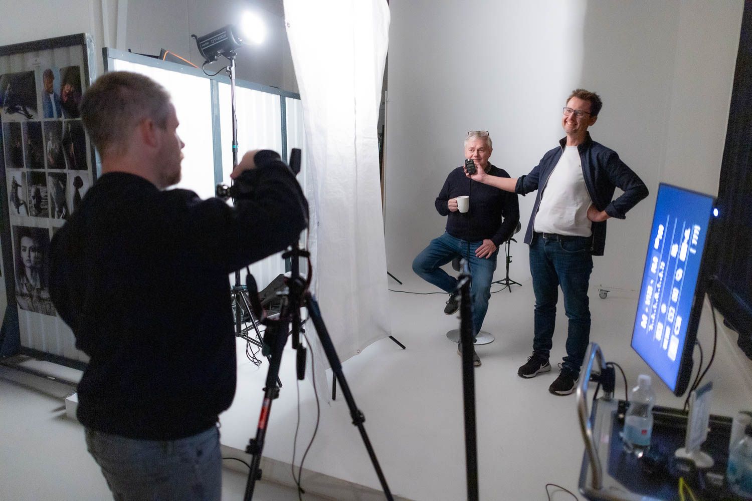 Photography studio with professional lighting setup and multiple monitors visible.