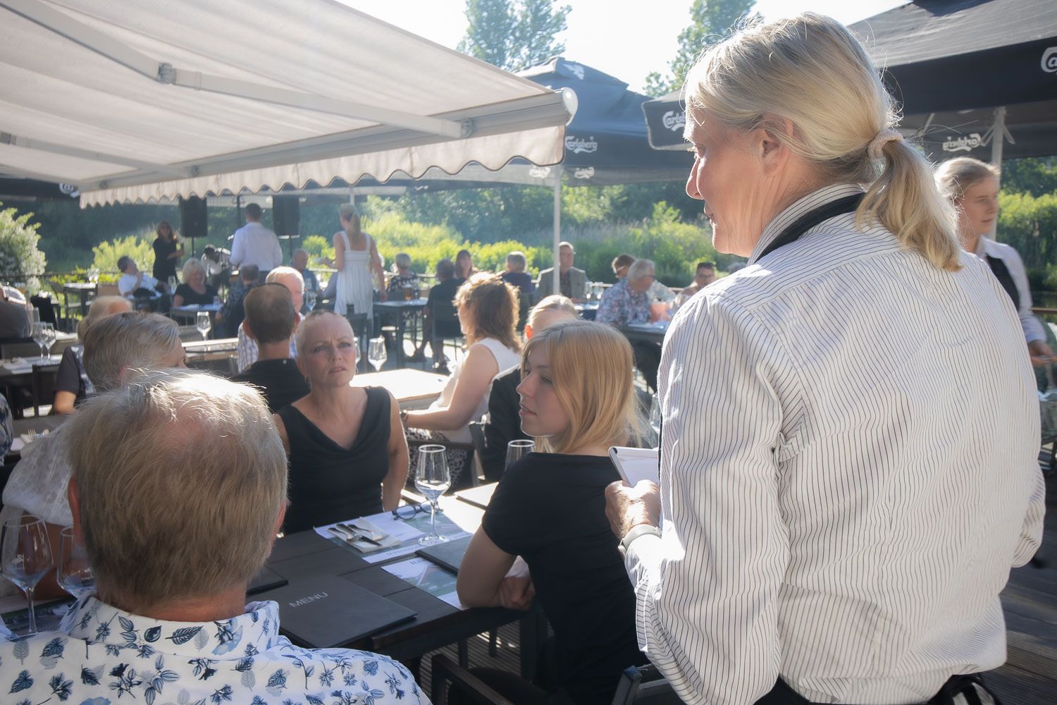Professional kitchen staff plating elegant dishes at an outdoor dining venue.
