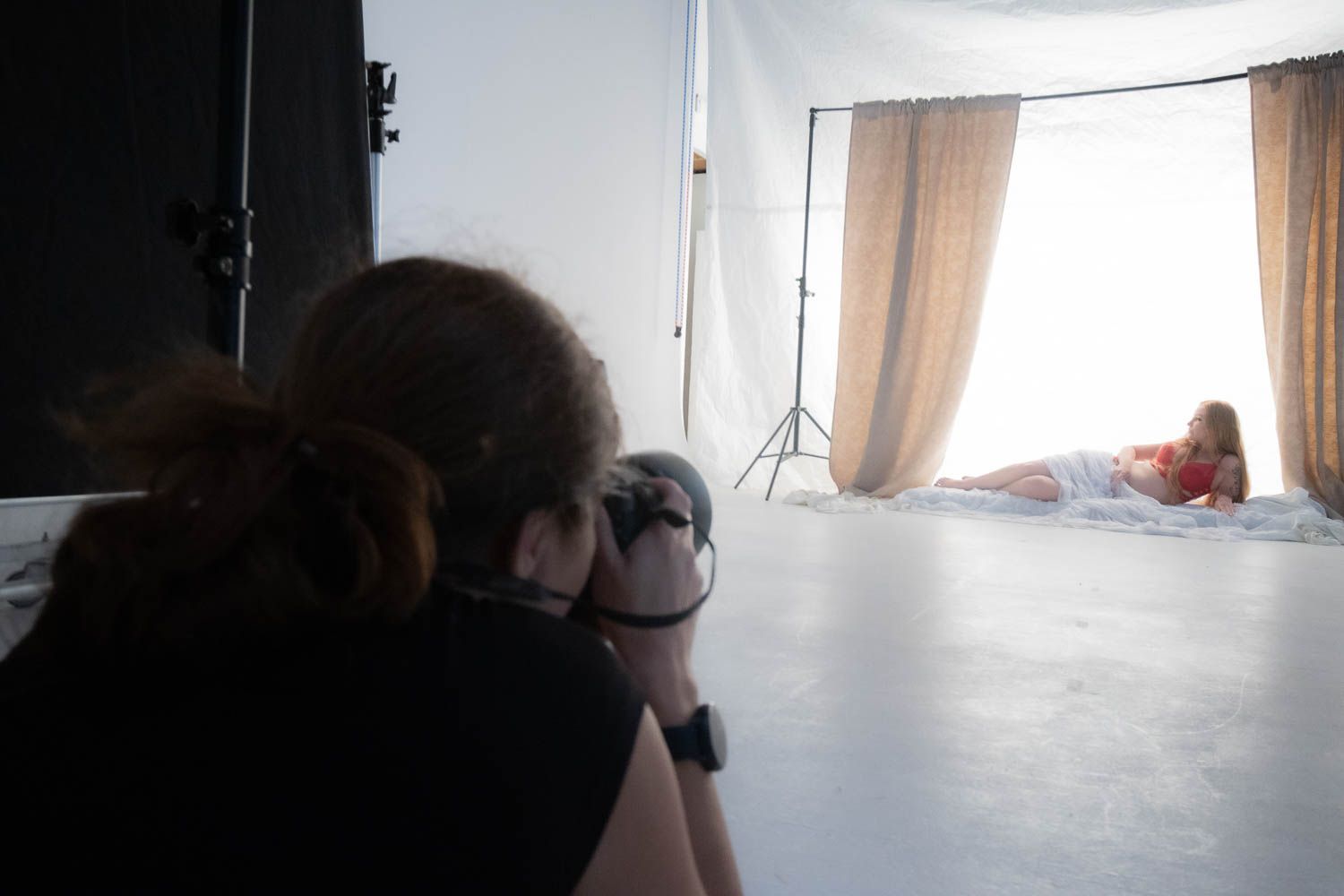 Photography studio interior with natural window light and professional equipment setup.