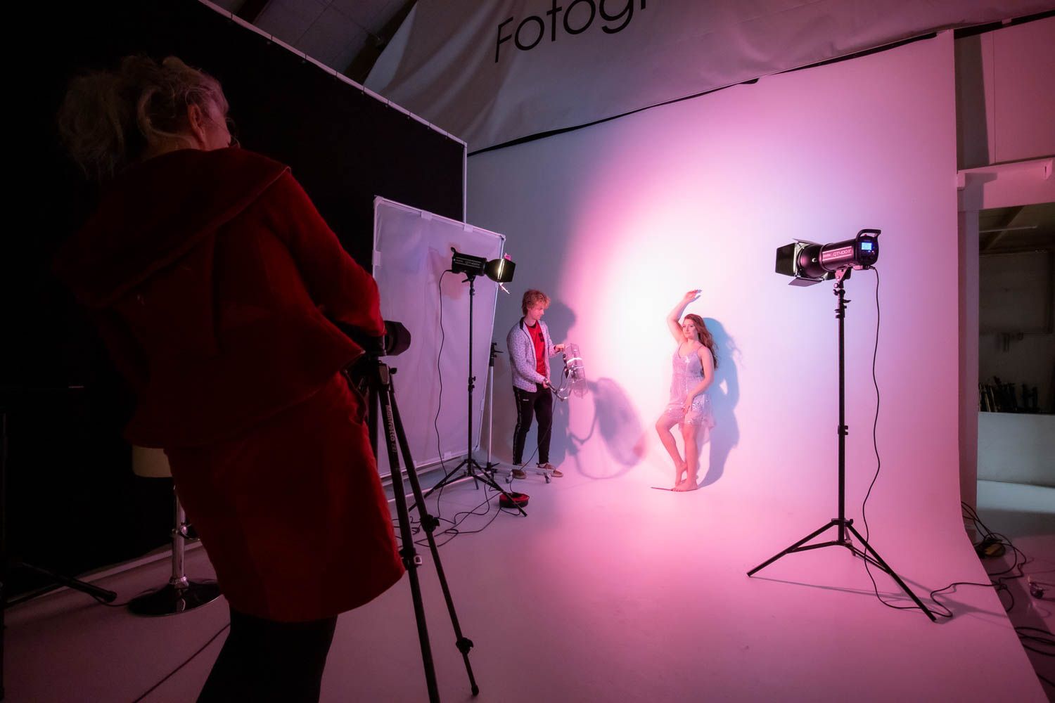 Creative photography session with pink lighting and multiple exposure effects in studio setting.
