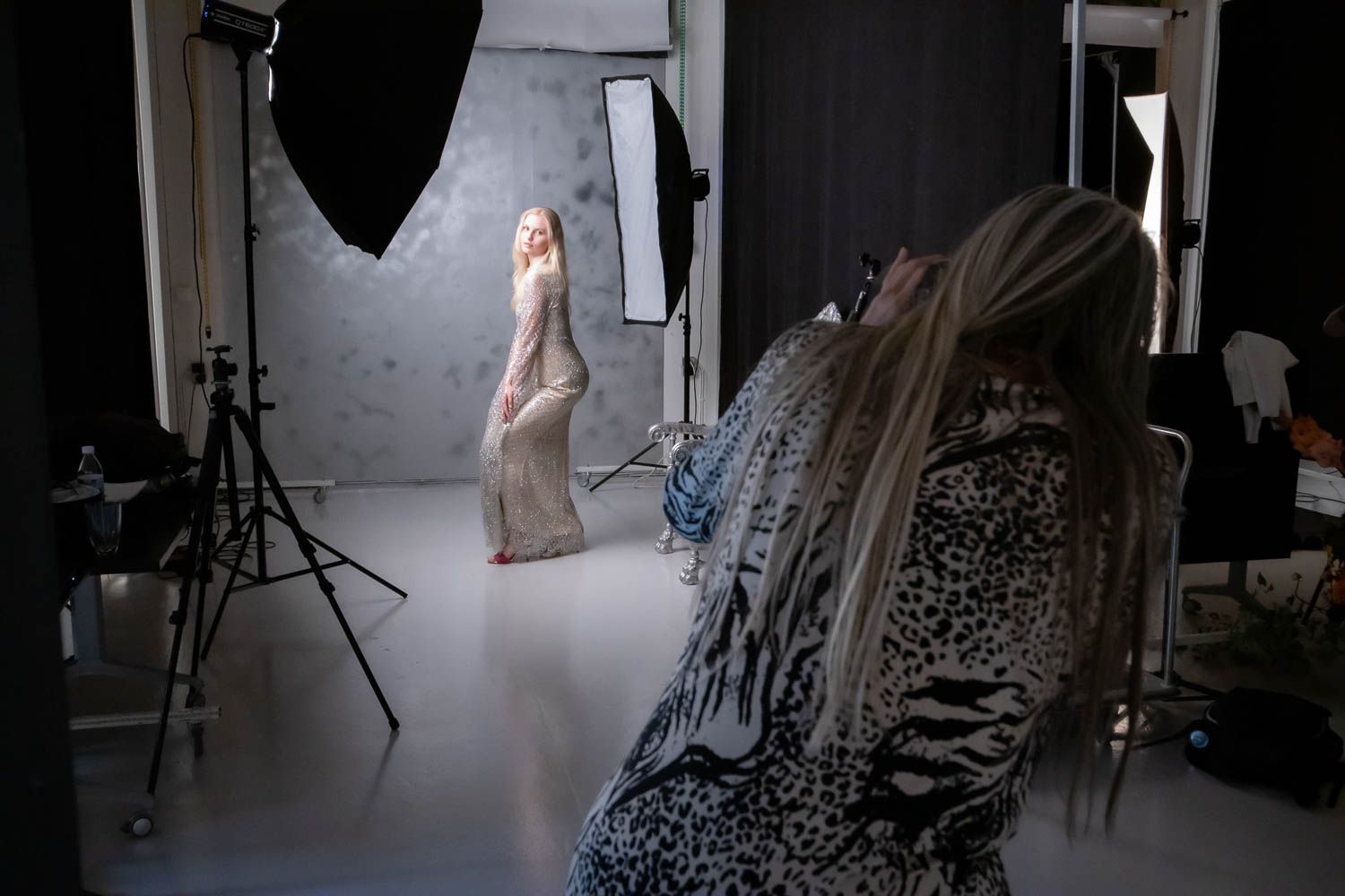 Studio photography session with dramatic side lighting and professional equipment visible.