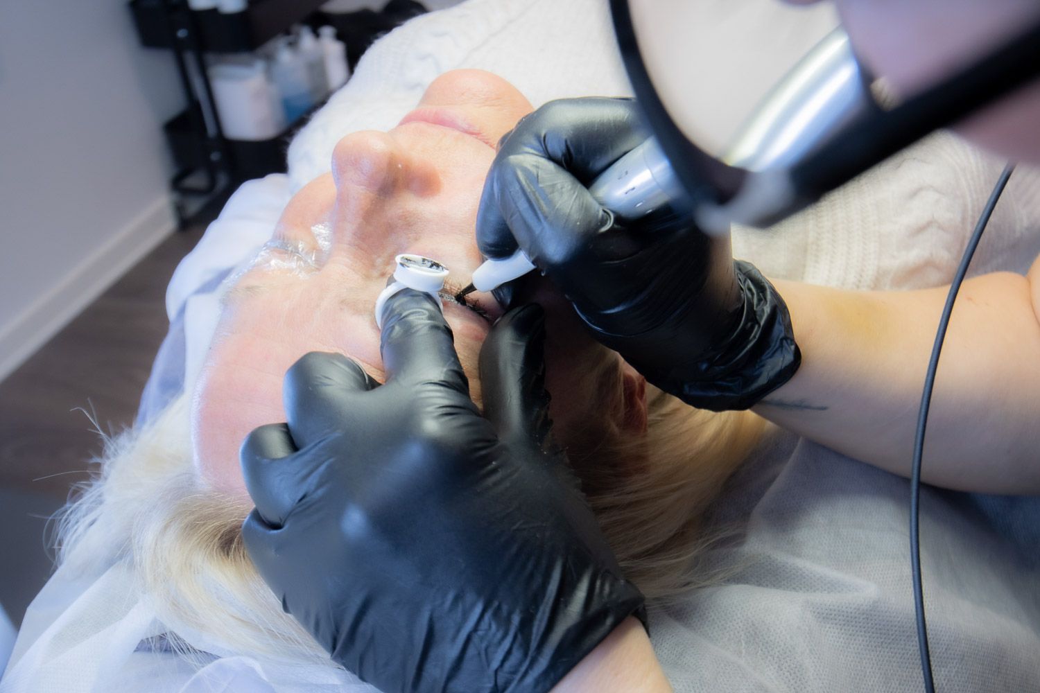 Cosmetic procedure being performed with specialized equipment in a clean clinical environment.