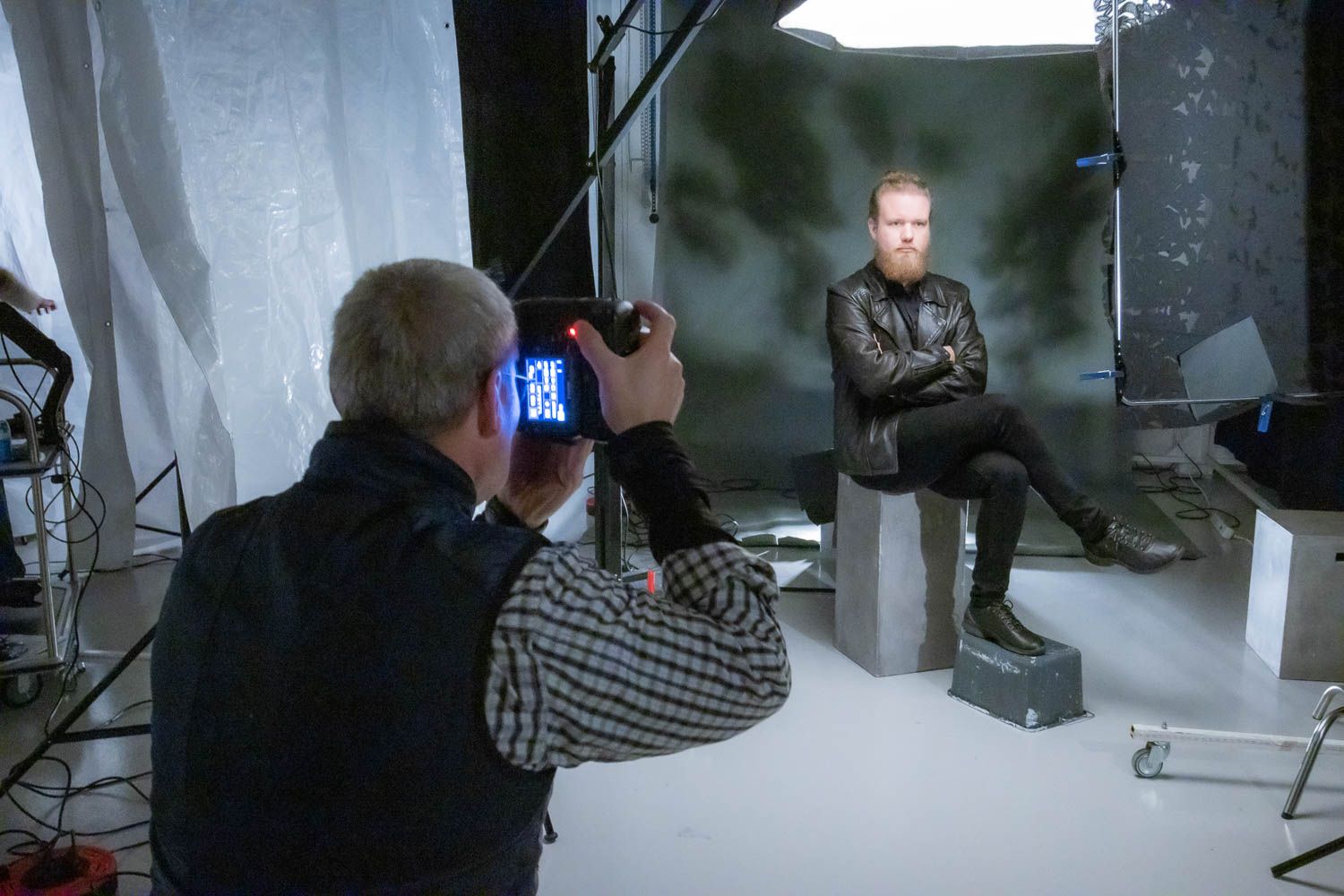 Photography studio setup with lighting equipment and monitors visible during a professional photo shoot.