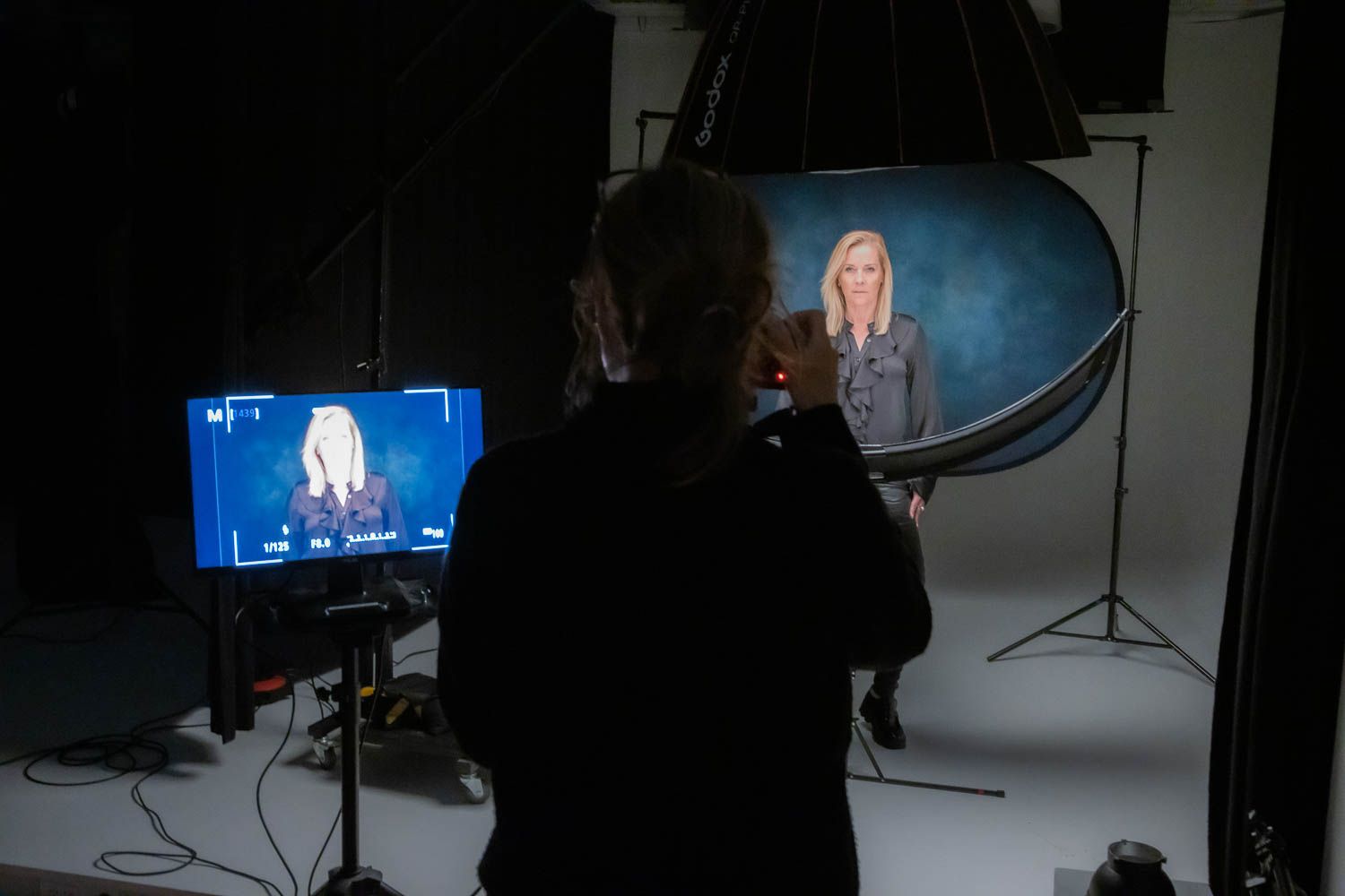 Photography studio setup with monitors and lighting equipment visible.