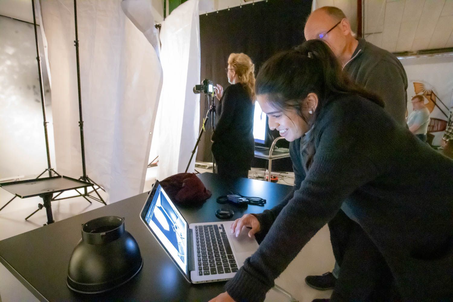 Photography crew working with equipment and lighting in a bright studio space.
