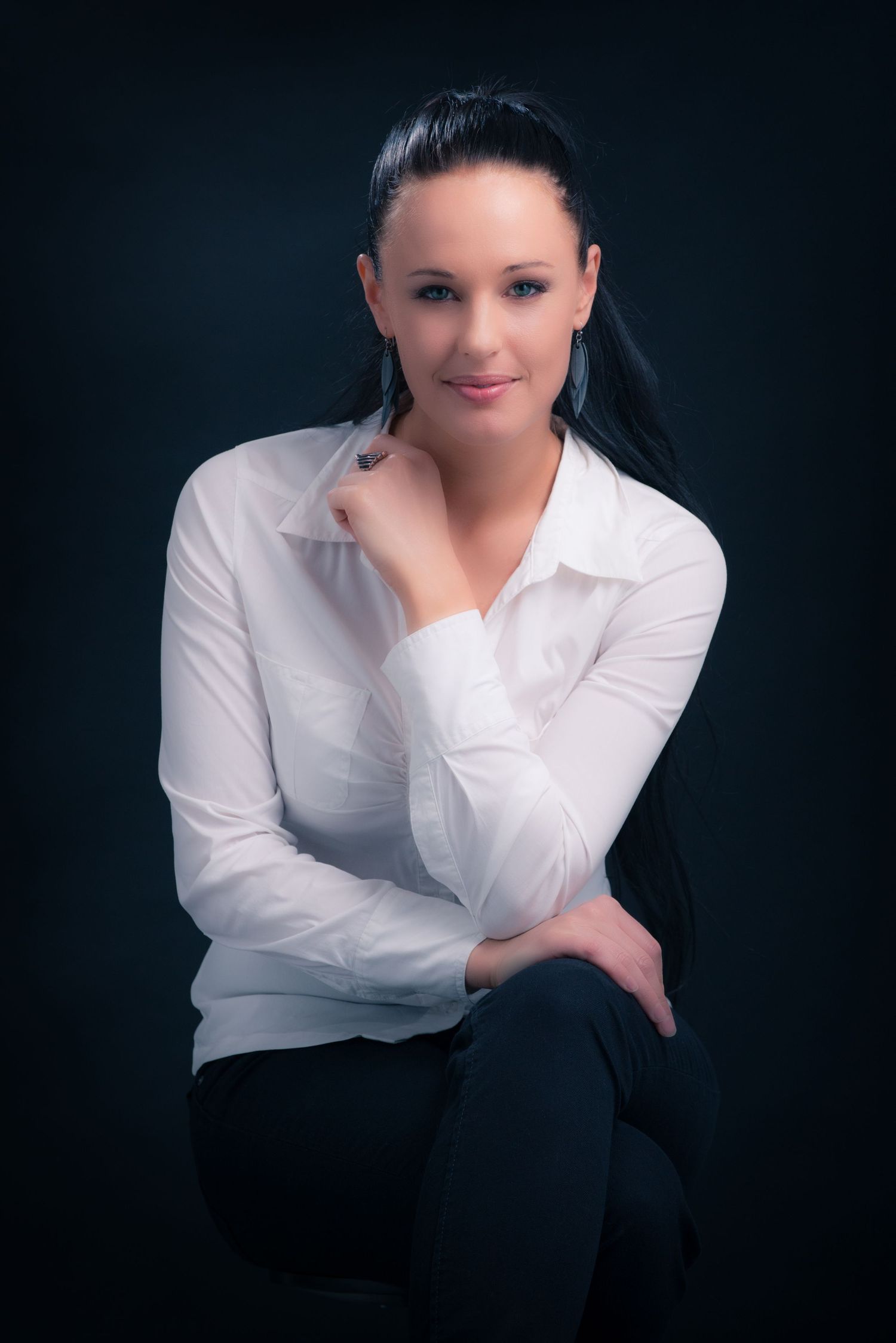 Professional studio portraits featuring person in white shirt against dark background.