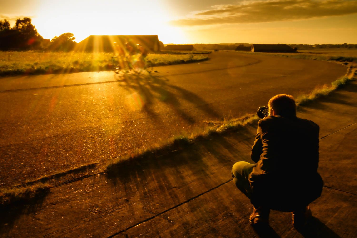 Golden sunset landscape with silhouetted photographer in foreground.