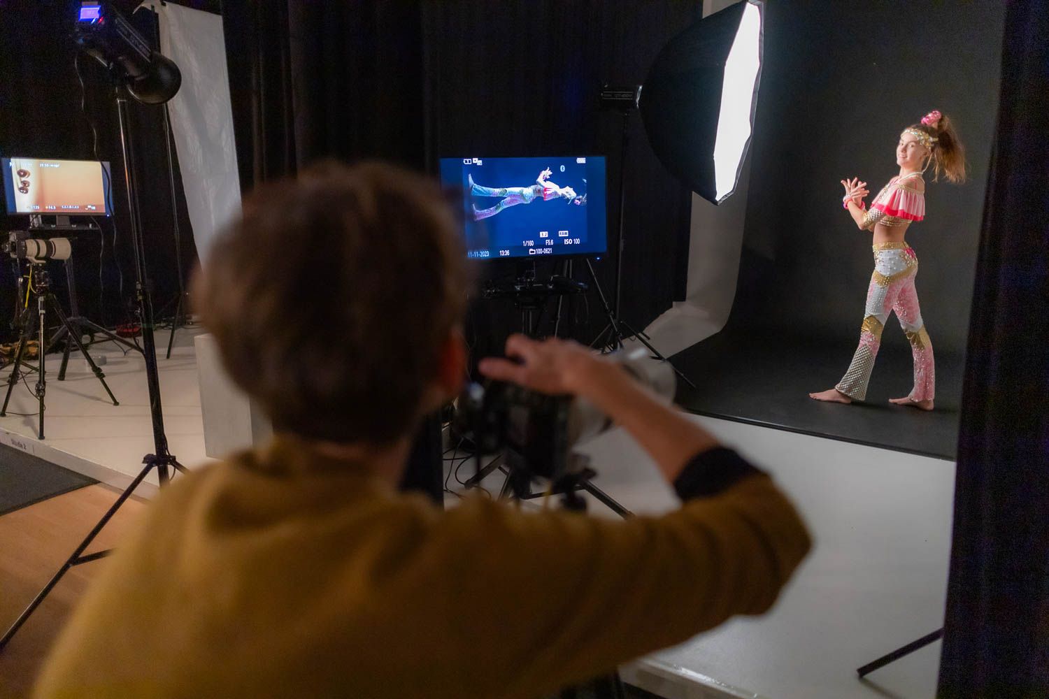 Studio photography session with blue screen backdrop and professional lighting equipment.