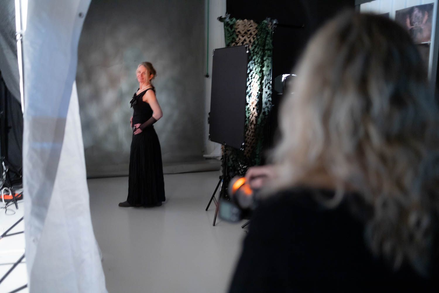 Photography crew setting up professional lighting equipment in a studio space.