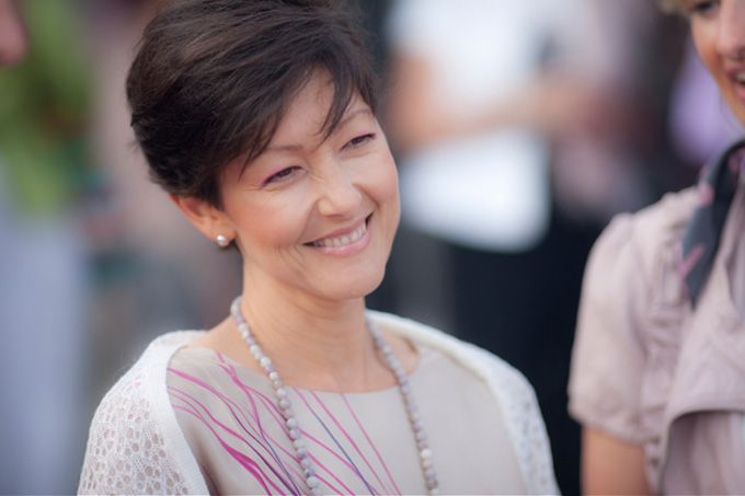 Portrait of someone wearing a beige top with a delicate necklace.