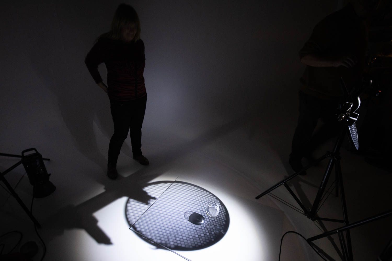 Studio lighting setup with spotlight creating dramatic circular effect on floor.