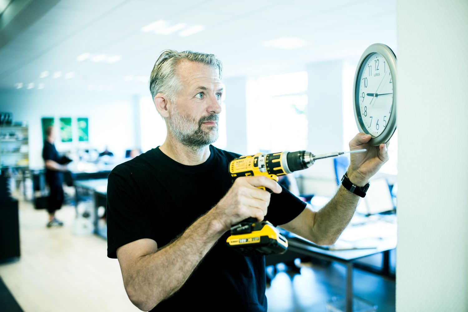 Technician using power tools during an installation in an office space.