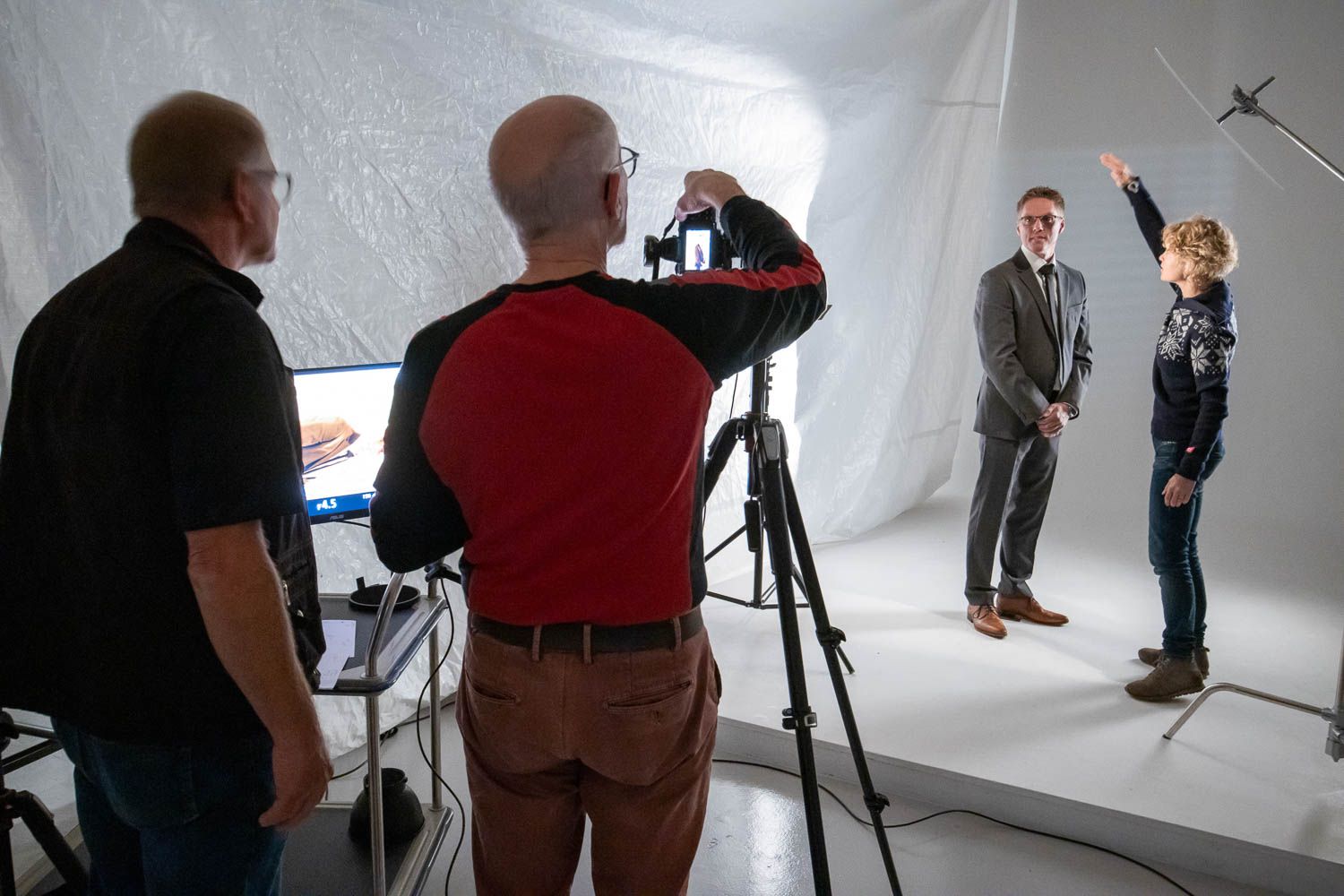 Wide shot of photography studio showing crew and equipment during shoot.