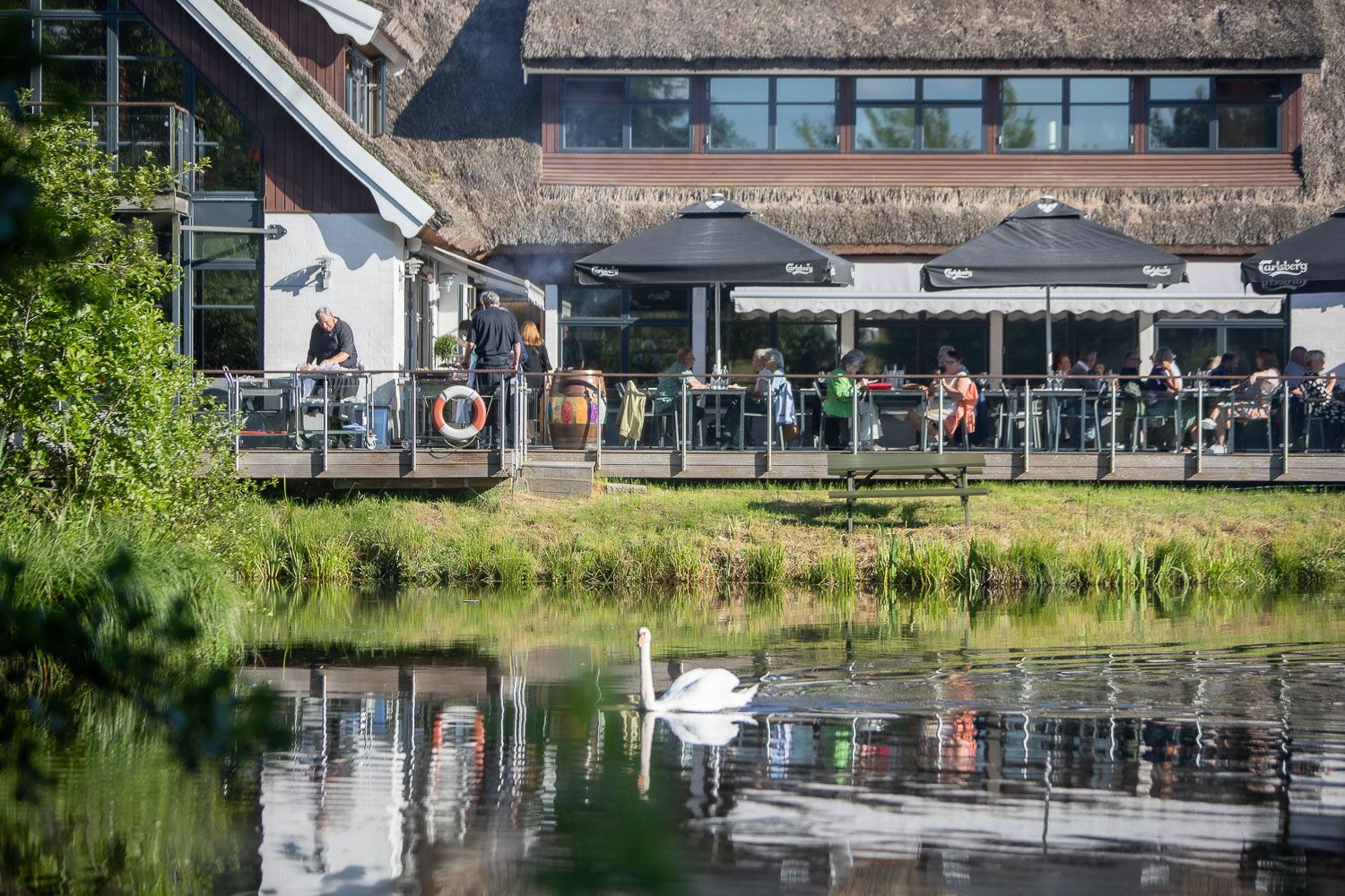 Waterfront restaurant patio with outdoor seating along a scenic canal.