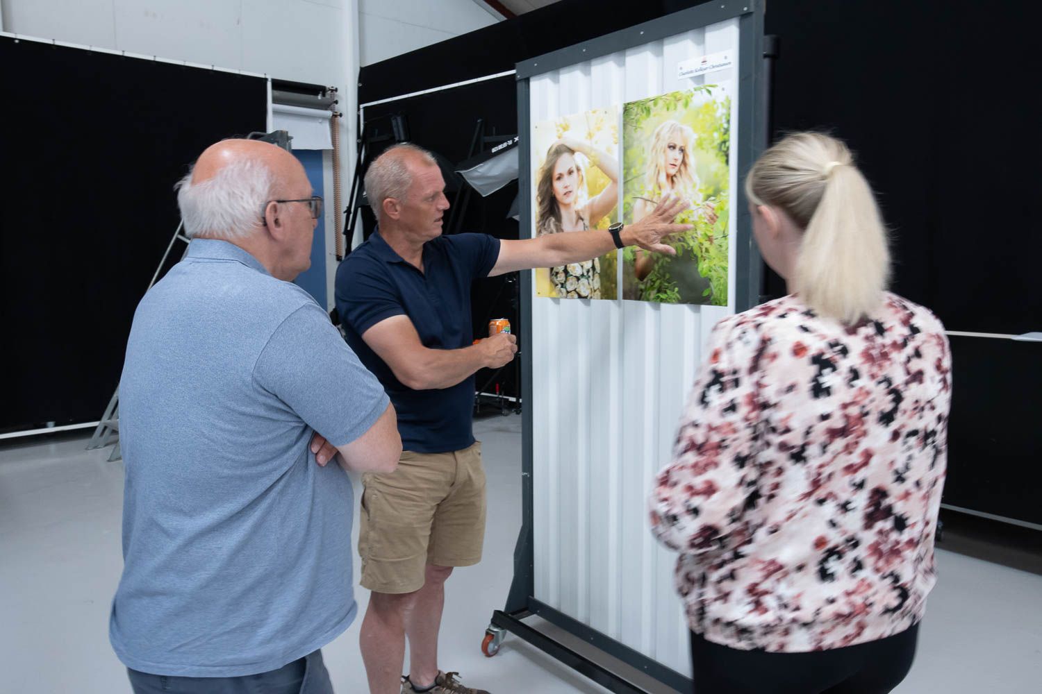 Photography studio viewing session with prints displayed on a light wall.