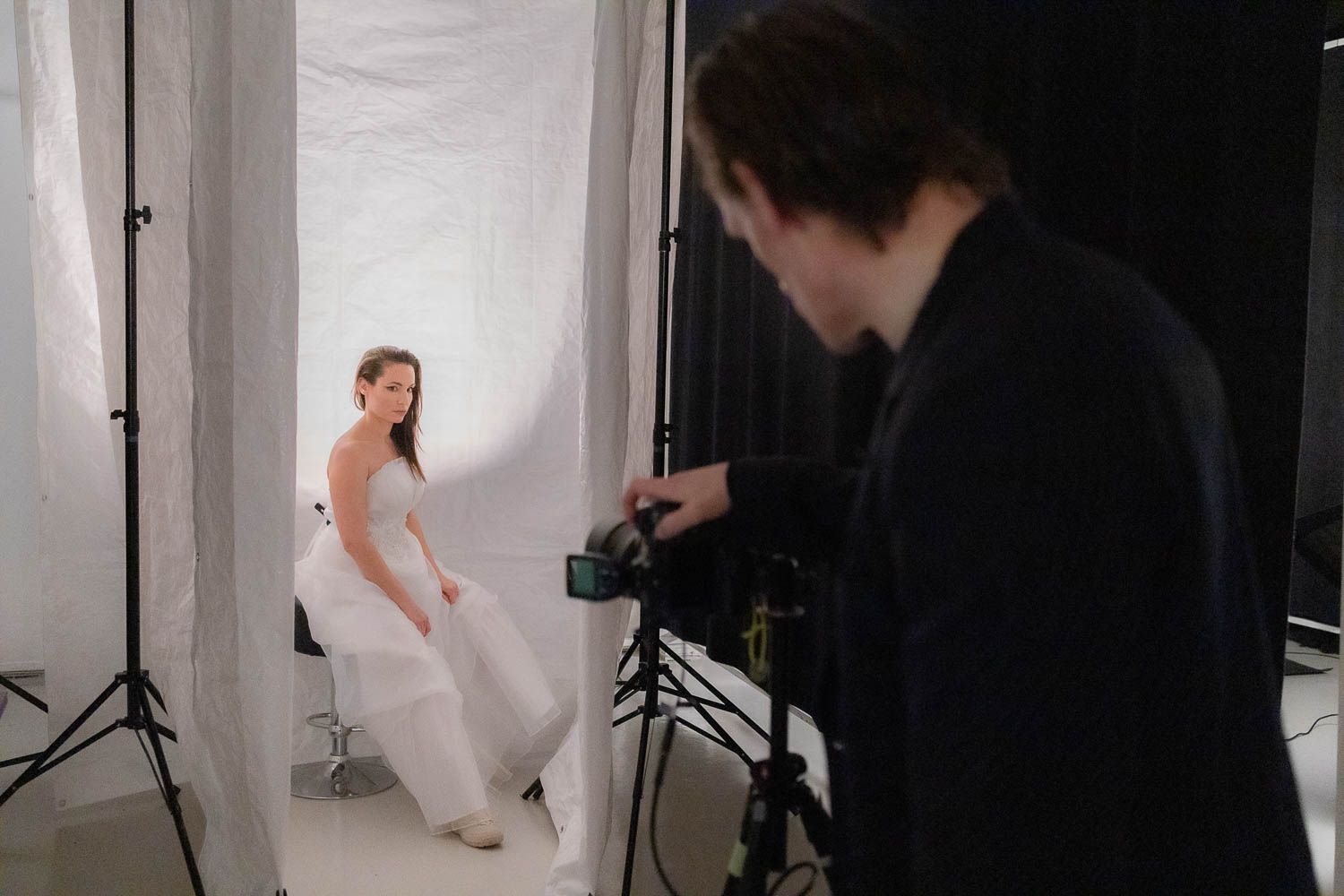 Professional photo shoot in progress with white backdrop and studio lighting visible.